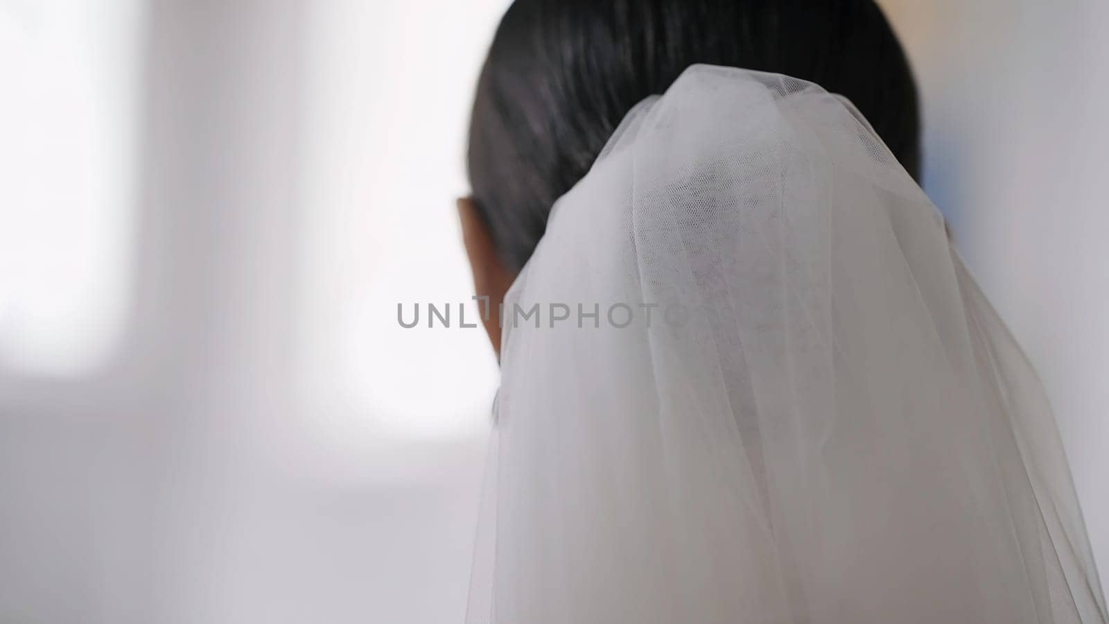 A beautiful couple walking through the church. Action.A view of the people from behind who decided to get married in a church. by Mediawhalestock