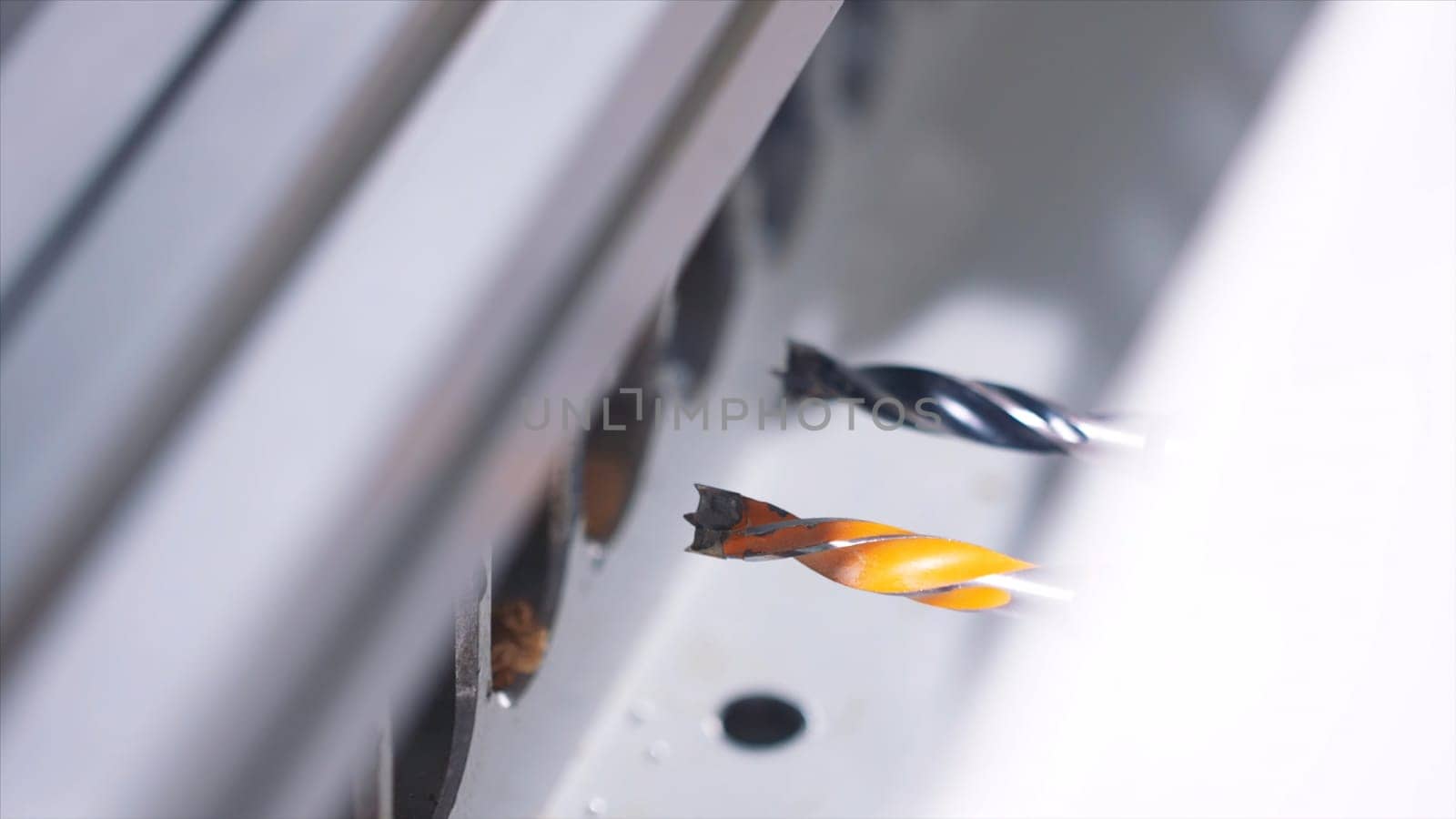 Close-up of working automatically wood drilling machine at the furniture factory. Production, manufacture and woodworking industry concept