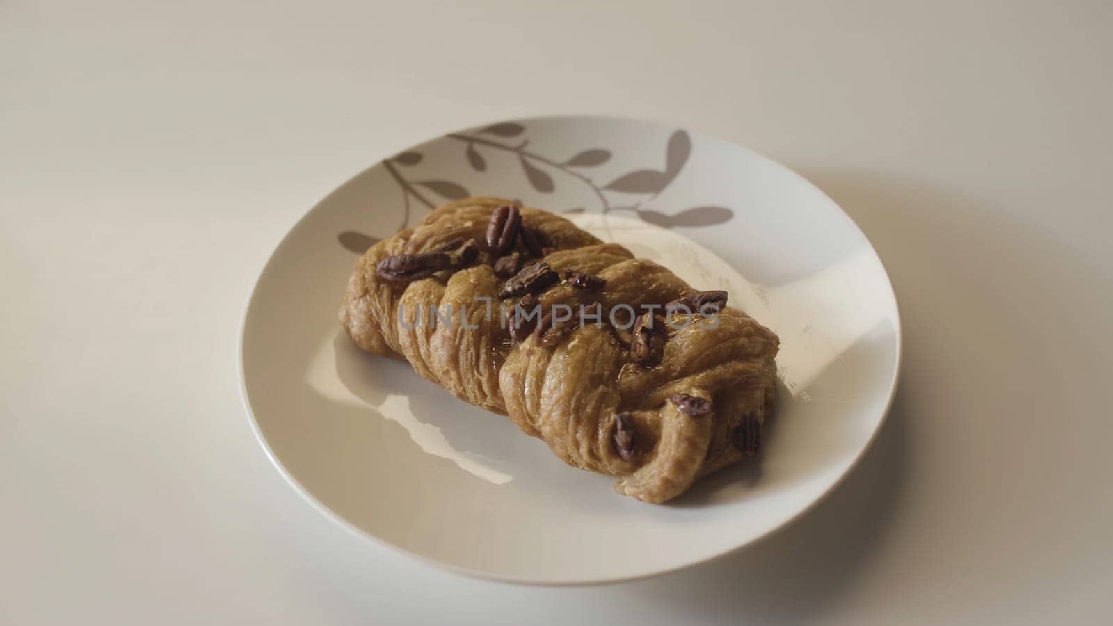 Several plates with delicious pastry products placed in one row on wooden table. Close up of yummy bread products on white table background.