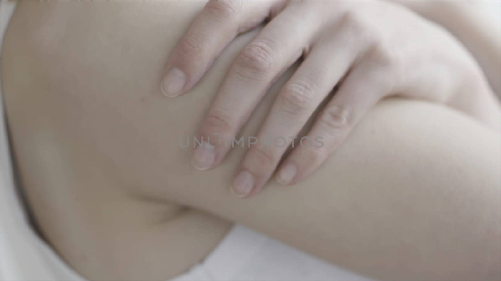 Close up for woman hand squeezeing her houlder, anxiety or worry concept. Body parts, girl hand touching her gentle shoulder.
