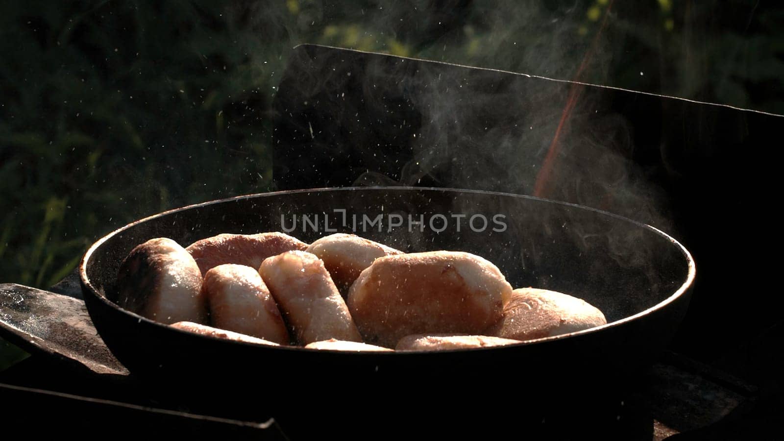 Picnic on the street. Creative . A large saucepan on which delicious meat is fried and smoke is coming , cutlets are made in nature . High quality FullHD footage