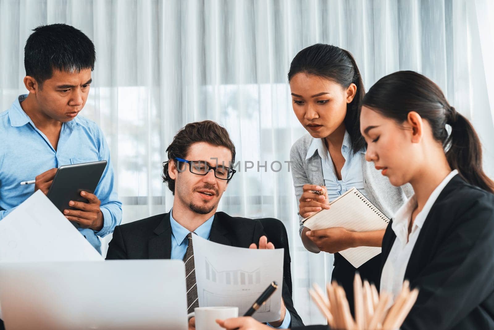 Diverse of business people from various ethnic group working in modern office environment. Productive and multi ethnic office workers engage in discussion for strategic business marketing. Meticulous