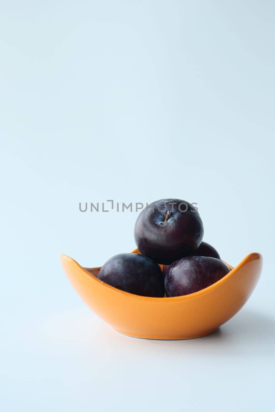 Fresh plums in a bowl on table ,