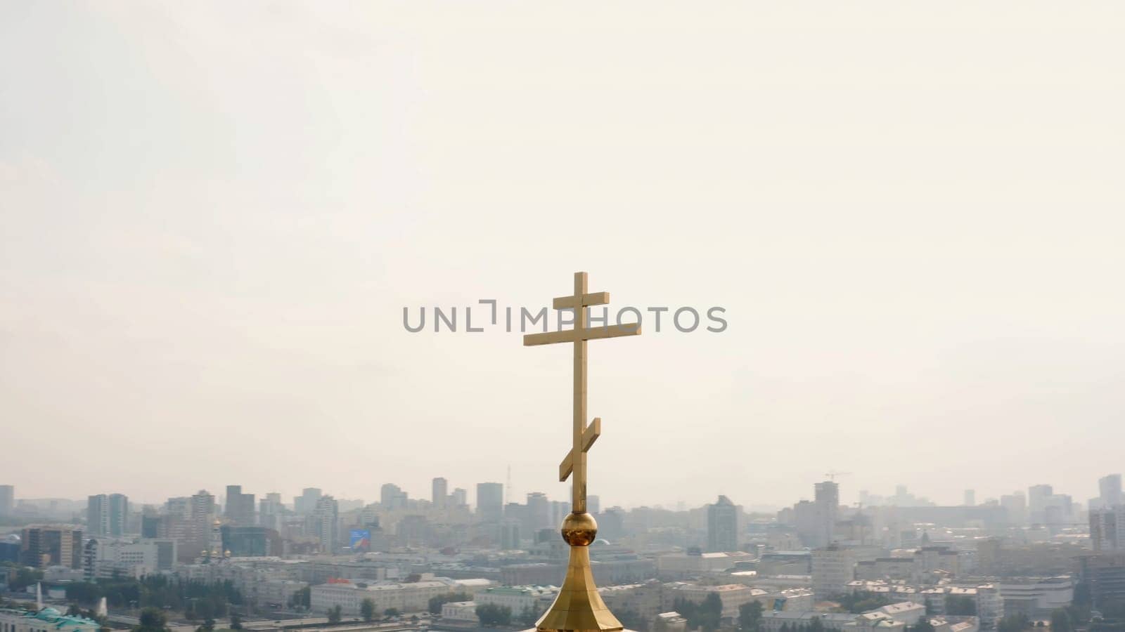 A large built-up city taken from a drone. Stock footage. A beautiful landscape with tall houses and offices, a temple and parks with a bright sun. High quality 4k footage