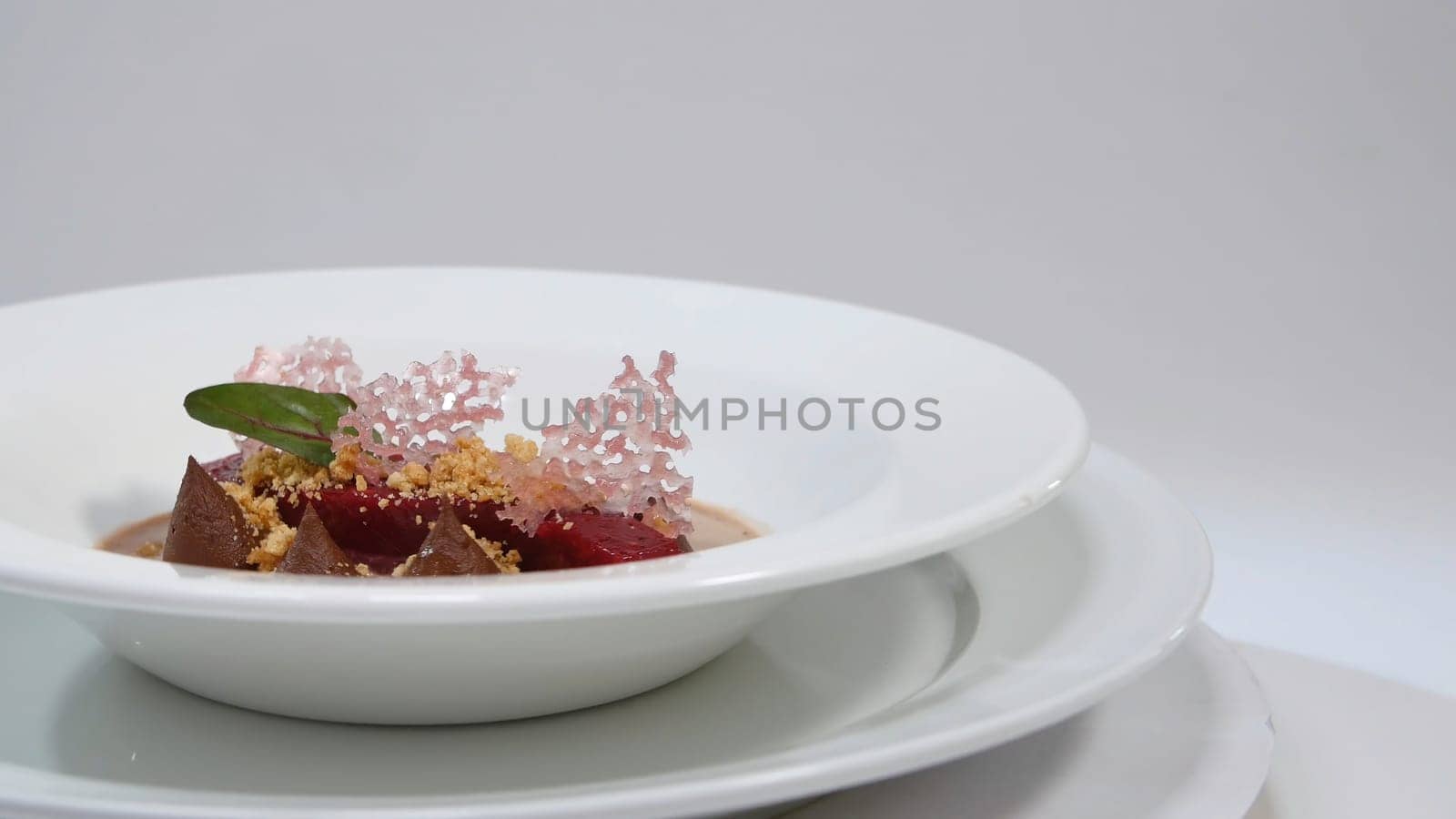 Salad of baked beets, arugula, cheese and nuts. Fresh salad with beets and oranges, food. Vegetarian lean lettuce from beet, onion, walnuts, serving on a white plate