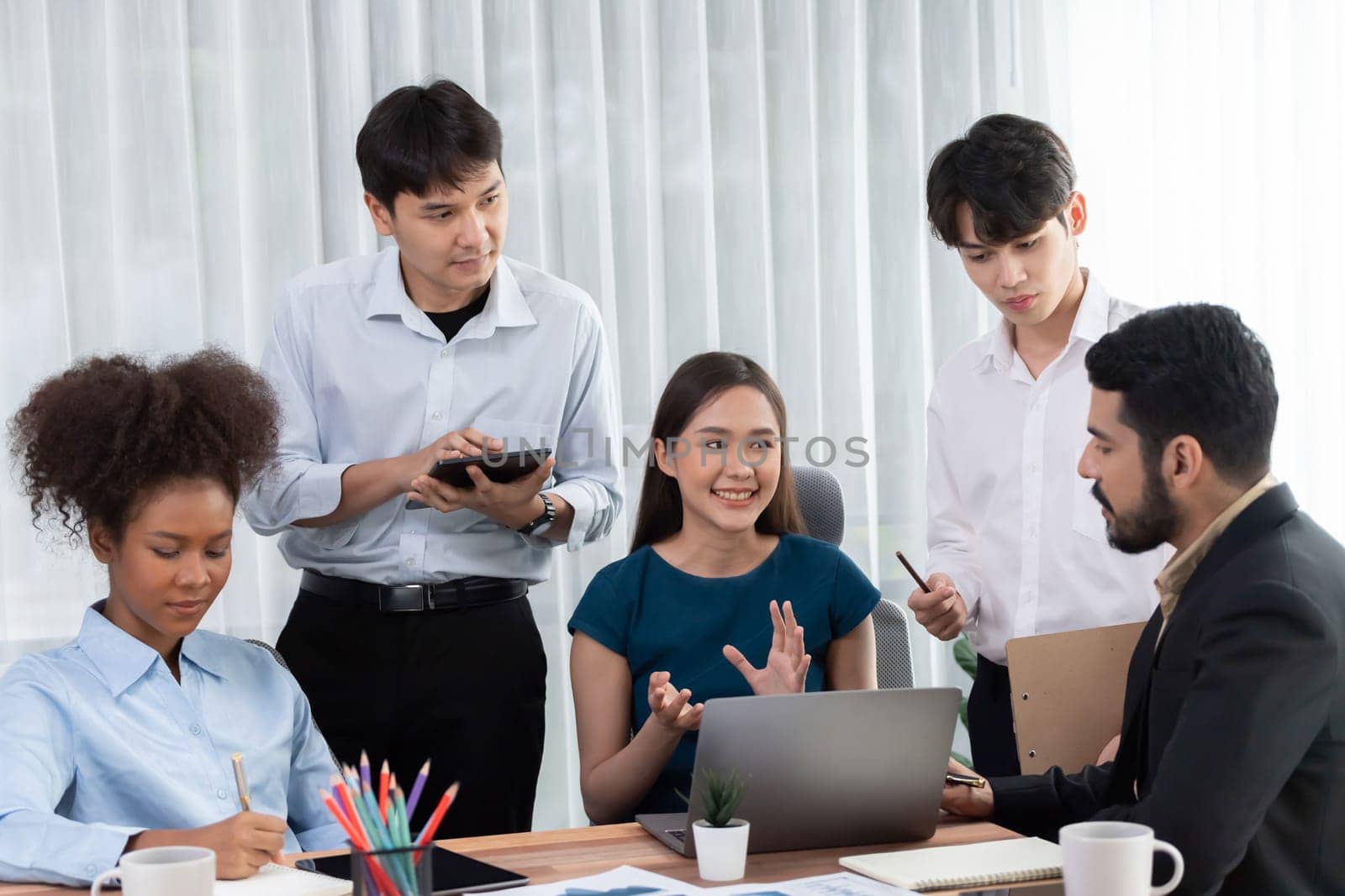 Happy diverse business people work together, discussing in corporate office. Professional and diversity teamwork discuss business plan on desk with laptop. Modern multicultural office worker. Concord