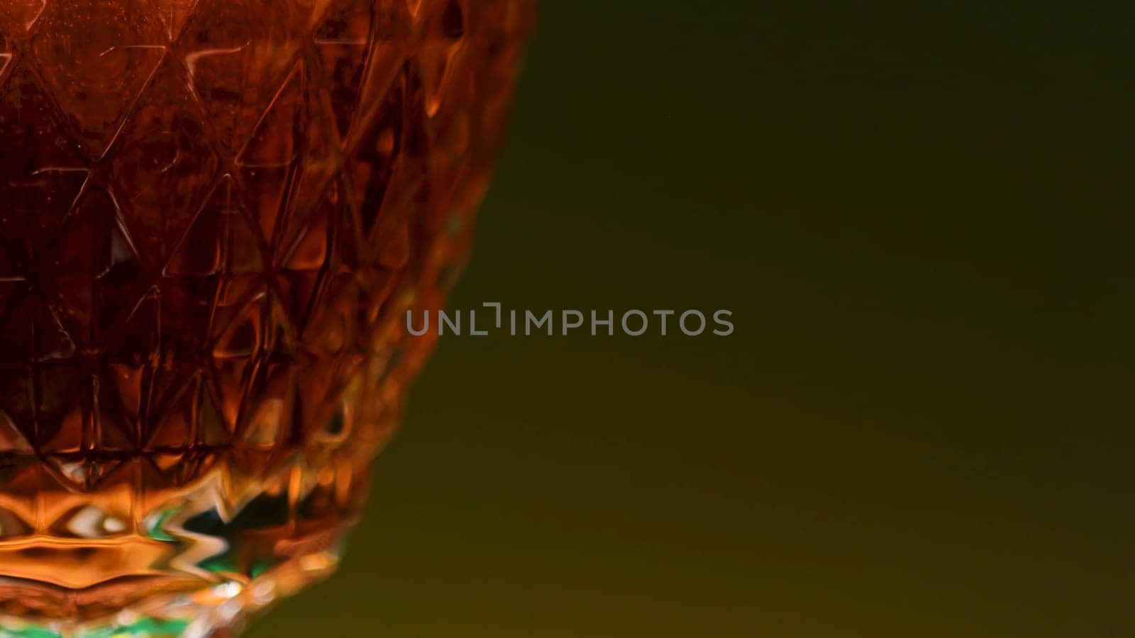 Close-up of carbonated dark drink in glass. Stock clip. Gases in alcoholic drink on isolated background. Transparent glass with carbonated dark drink in bar.