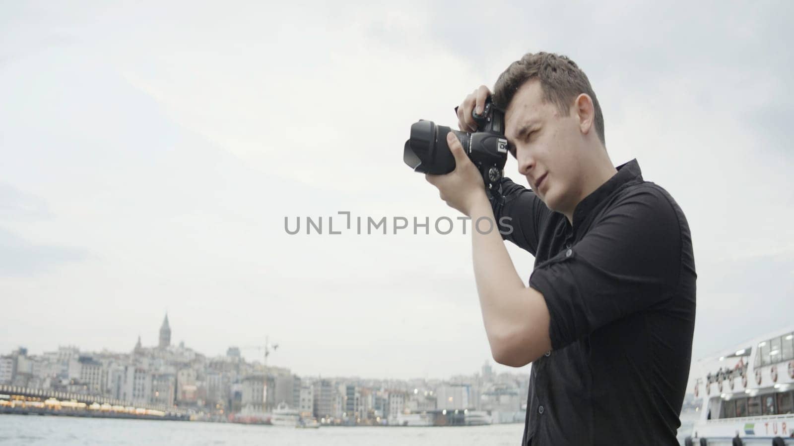 Photographer shoots architecture on camera. Action. Professional male photographer walks around city and shoots landscapes. Man walks around city with professional camera.