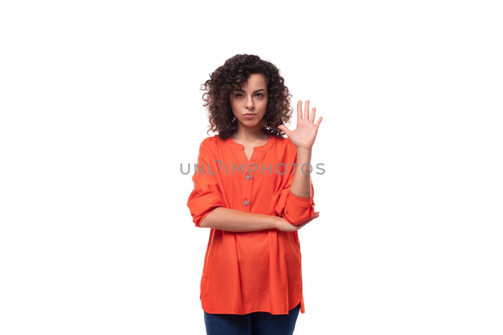 young smart caucasian business woman with wavy hair dressed in an orange blouse.