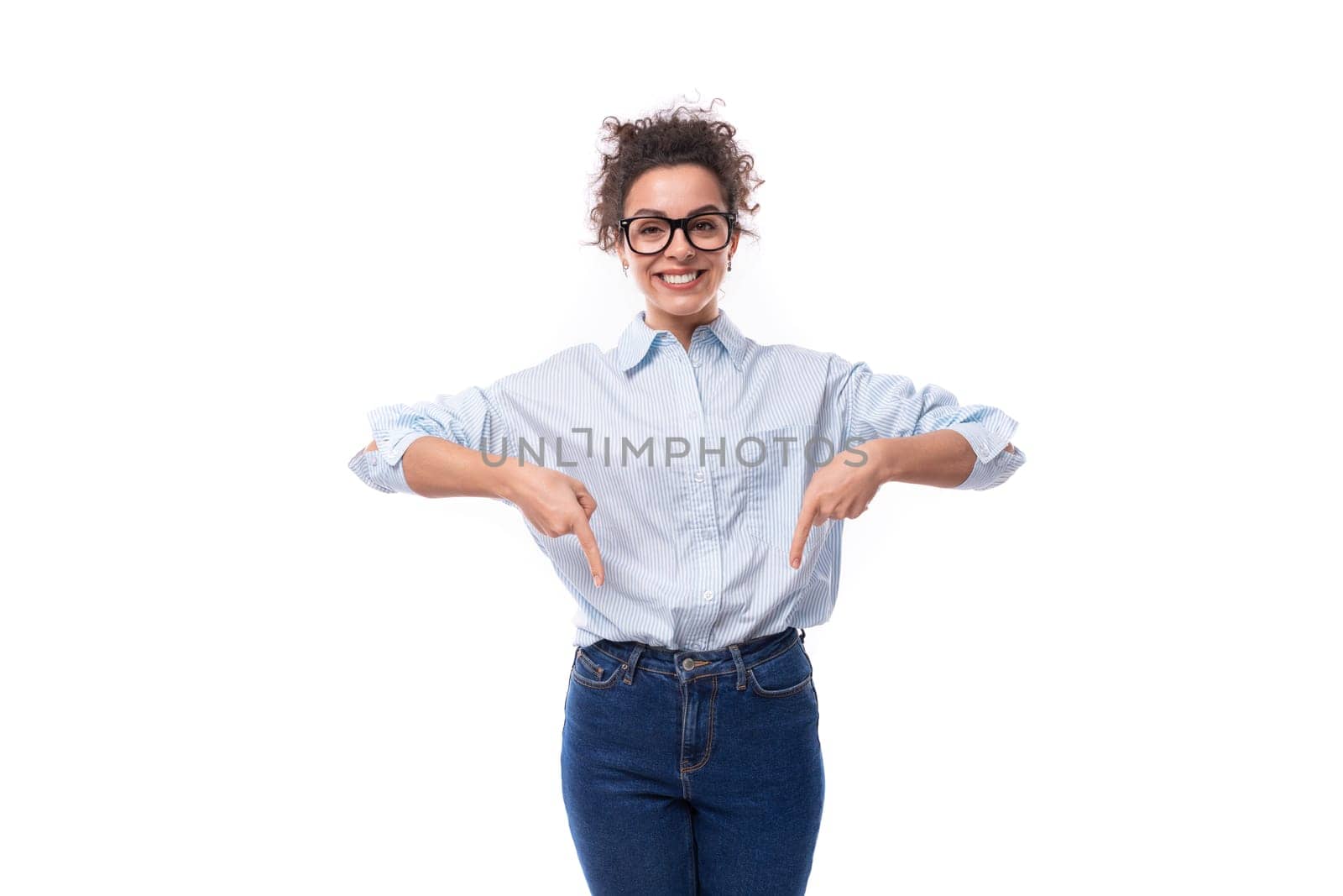 pretty slender young brunette curly employee of the company woman dressed in a light blue shirt and jeans by TRMK