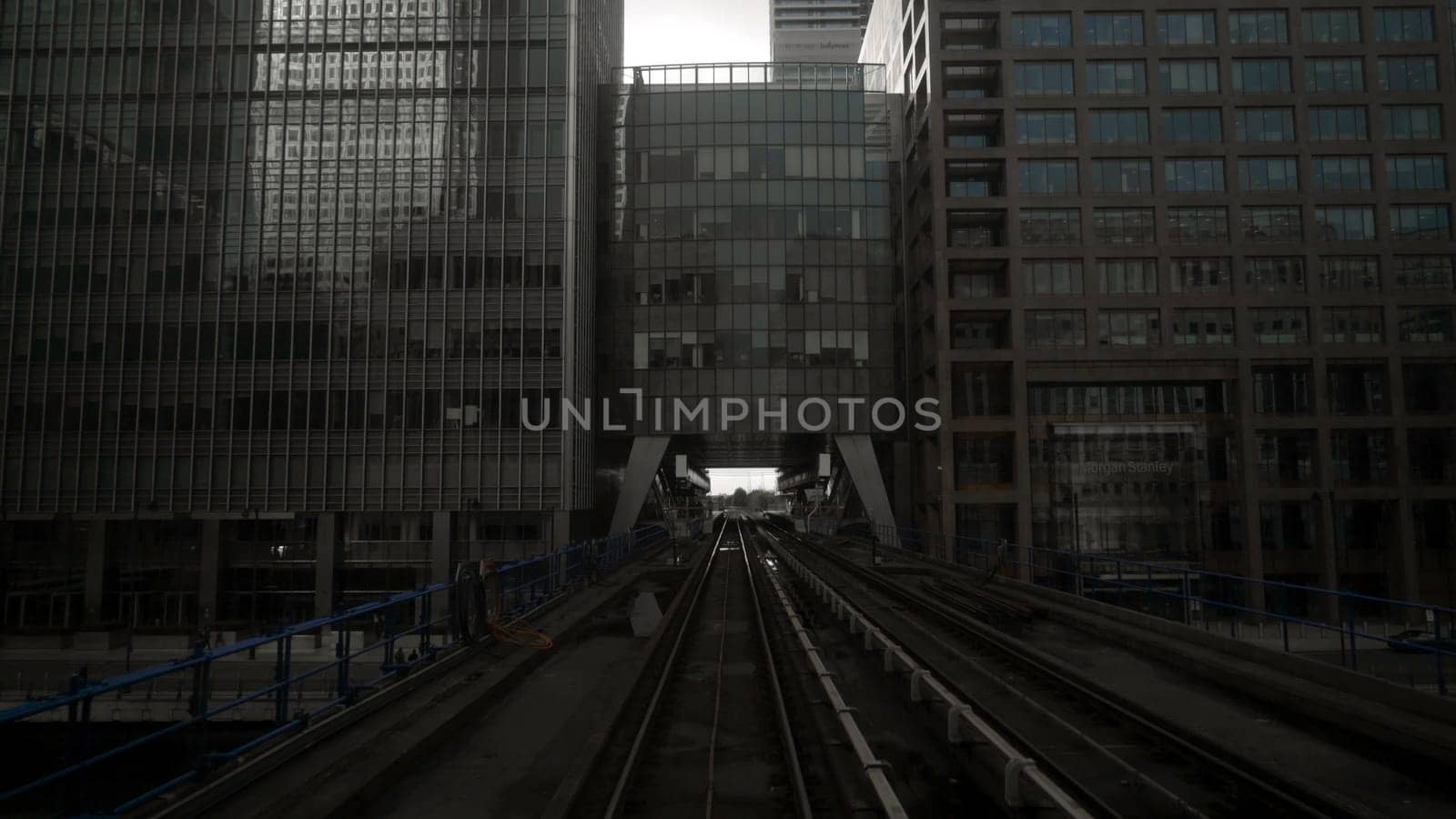 Skytrain tracks in business district of metropolis. Action. Skytrain in big city with skyscrapers in cloudy weather. Skytrain passes by skyscrapers with gloomy atmosphere. Gotham city.