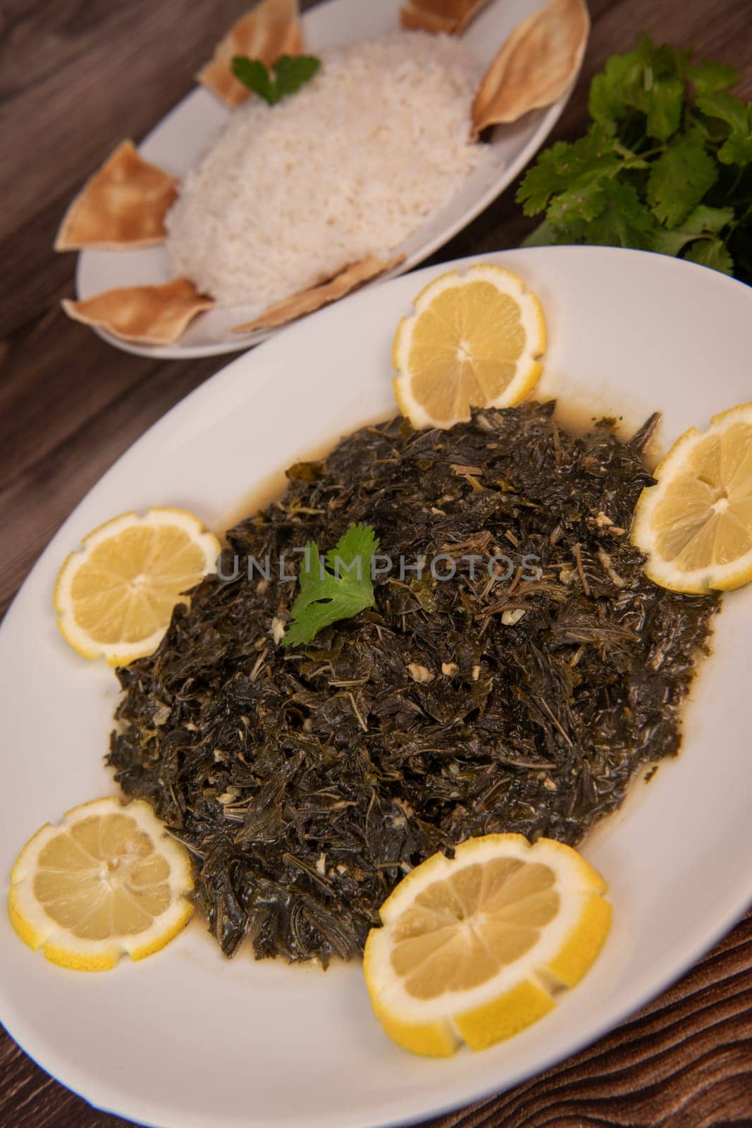 Lebanese recipe Mouloukhia , Melokhiyah, corete leaf and coriander rice chicken, grilled pita. High quality photo