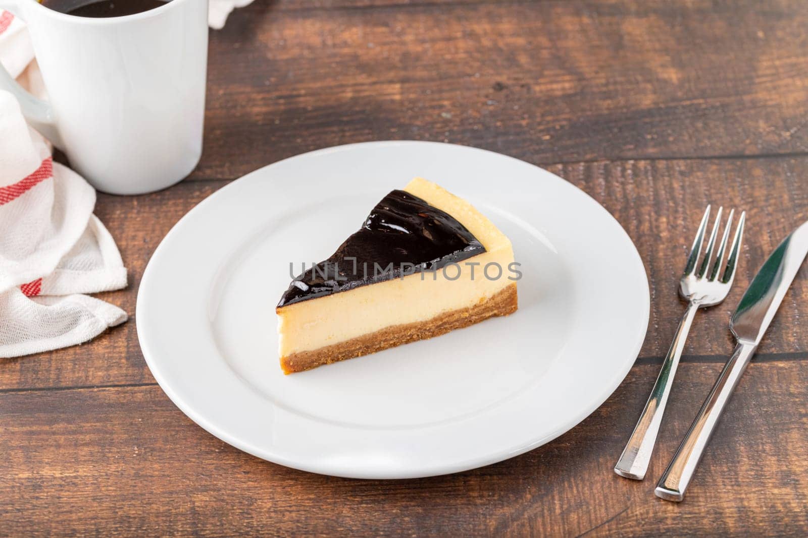 Chocolate cheesecake with brewing coffee on wooden table