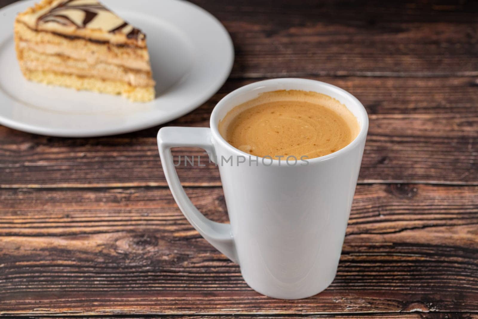 Relaxing americano coffee in white porcelain cup on wooden table