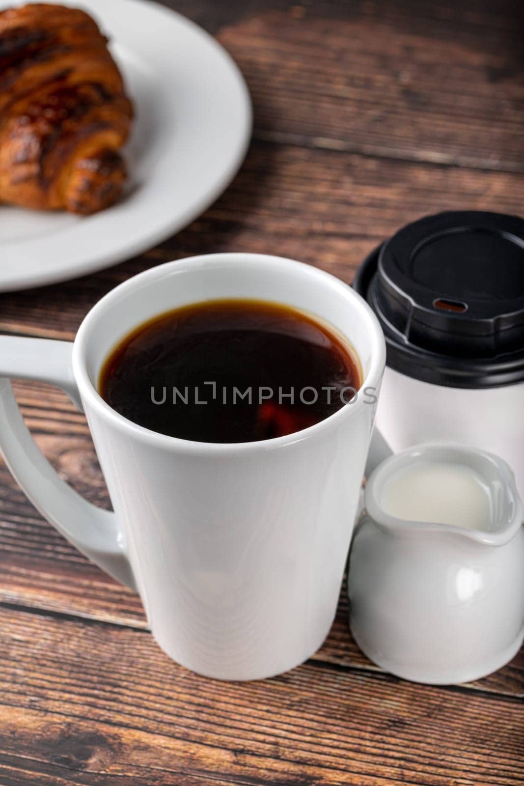 Filter coffee brewed in a white porcelain cup in a filter coffee machine, with milk and a take away glass by Sonat
