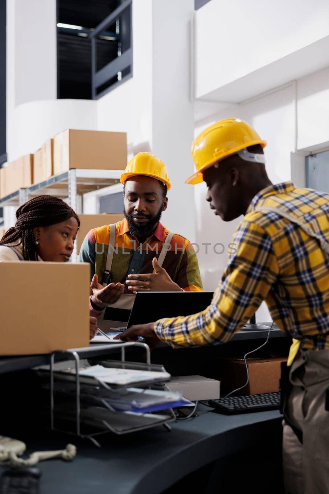 Postal workers checking parcel invoice on laptop and clipboard by DCStudio