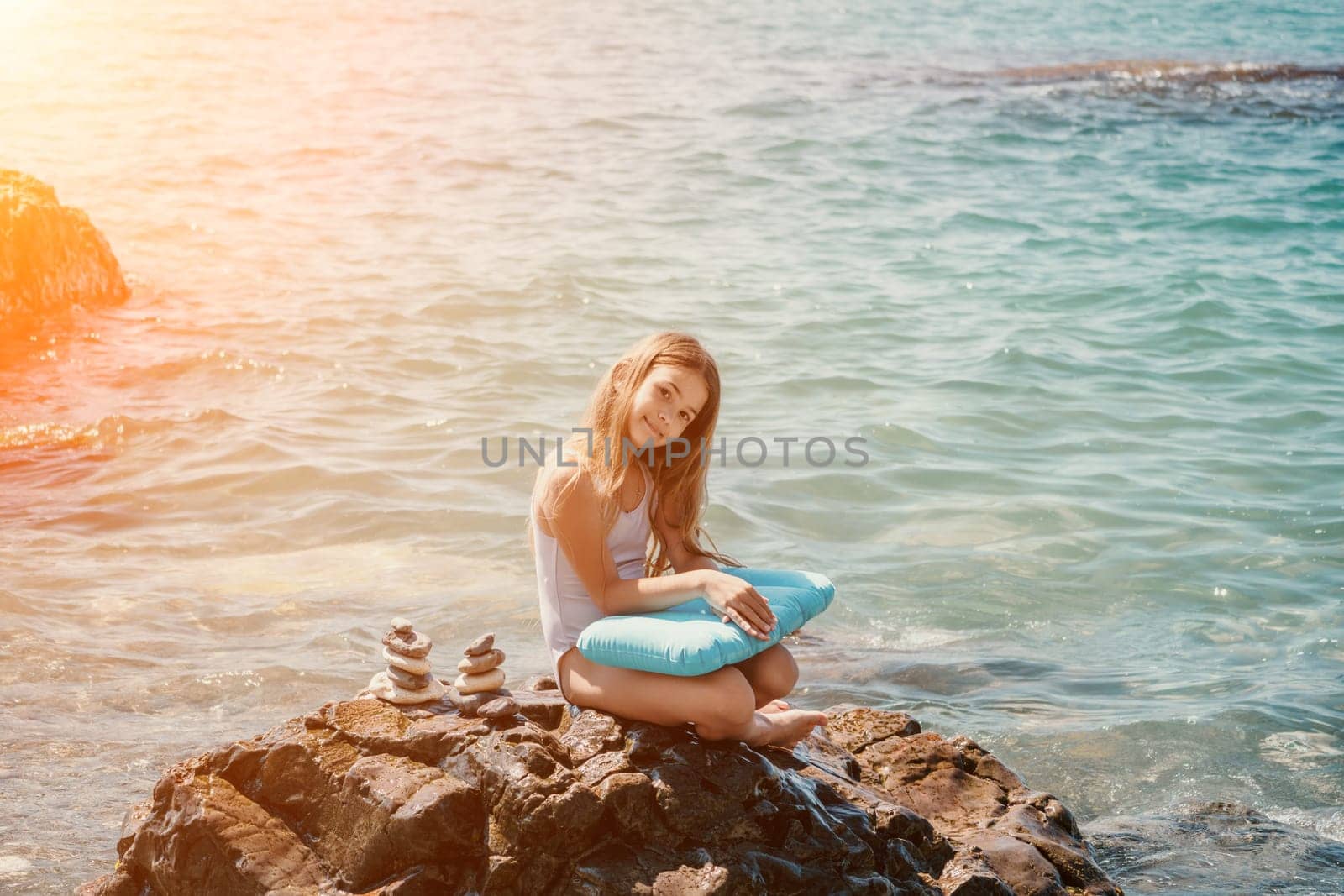 Balanced Pebbles Pyramid on the Beach on Sunny Day and Clear Sky at Sunset. Blue Sea on Background Selective focus, zen stones on sea beach, meditation, spa, harmony, calm, balance concept.