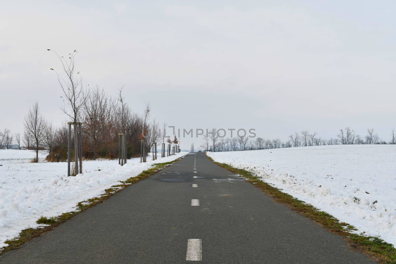 Road ploughed through by snow plough in winter. Roads plowed in winter. Concept of winter and winter road maintenance. 