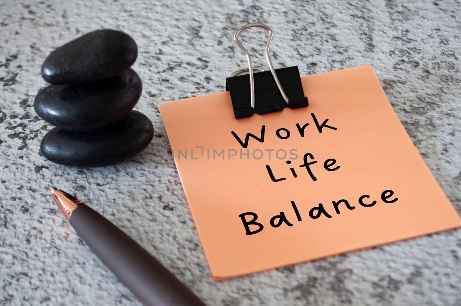 Work Life Balance text on sticky notes with stacked zen stones and pen. Working culture concept.