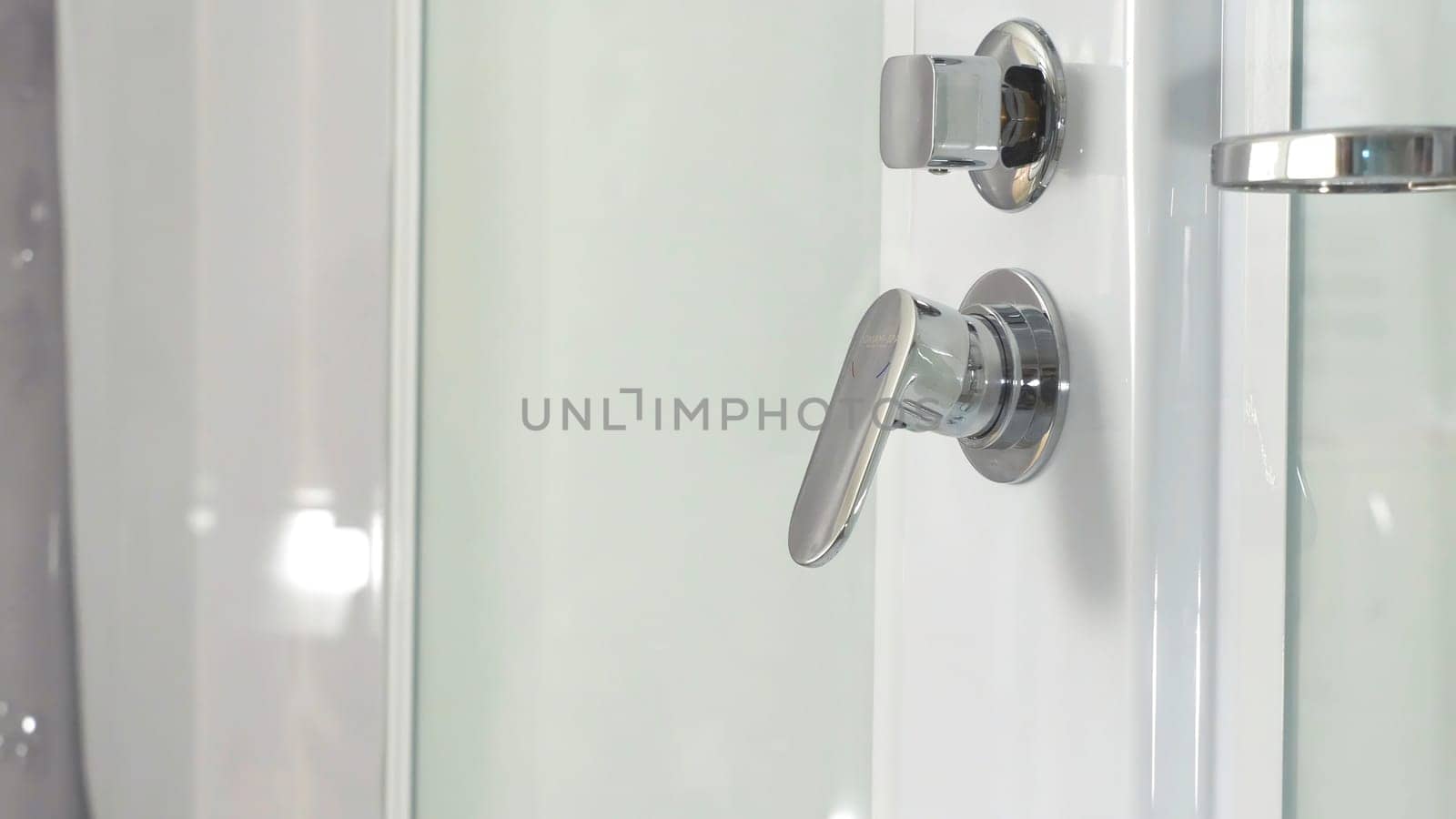 Closeup of a shower knob regulator and his water dispenser. Bathroom tap. Closeup of a shower knob regulator and water dispenser. Shower cubicle wth whirlpool jets, inside view 4K