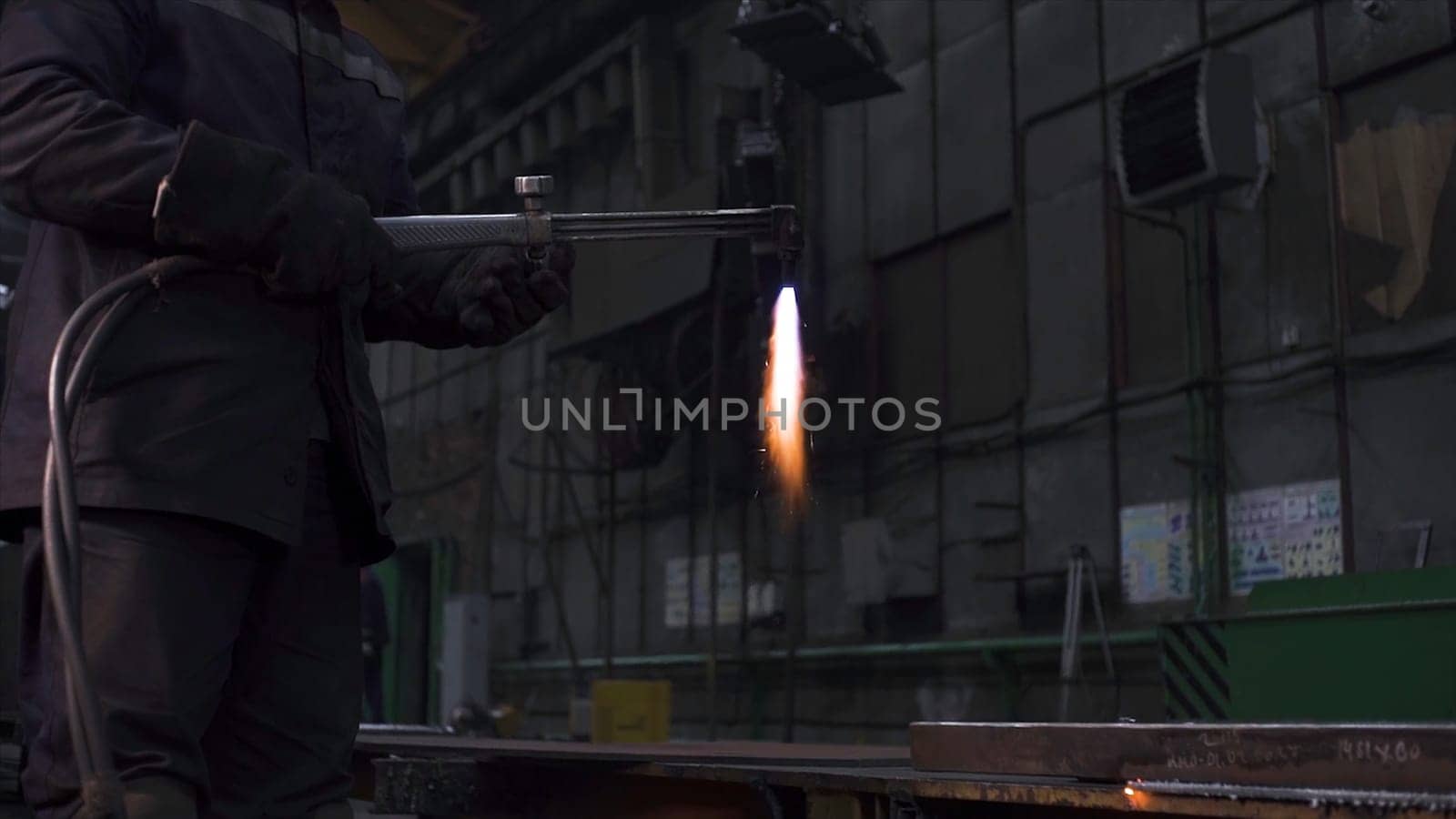 Welding worker works on metal structure in factory. Clip. Welding work with metal at factory. Metallurgical plant and welding works.