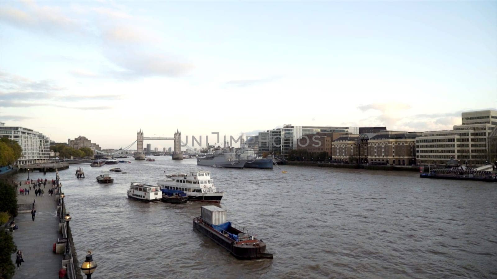 Canal in city on background of large bridge with towers. Action. Beautiful port channel is located in big city with beautiful bridge. Beautiful old architectural bridge with towers.