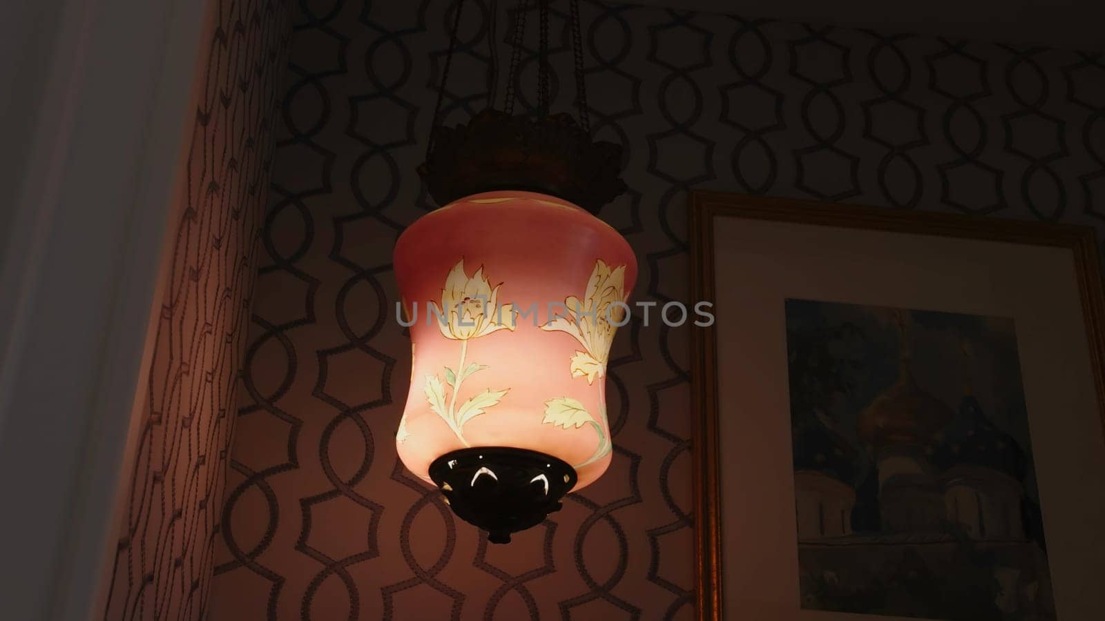 Antique luxury lamp in expensive interior. Creative. Stylish expensive floor lamp glowing in evening in interior. Expensive historical floor lamp in stylish interior of luxury apartments.