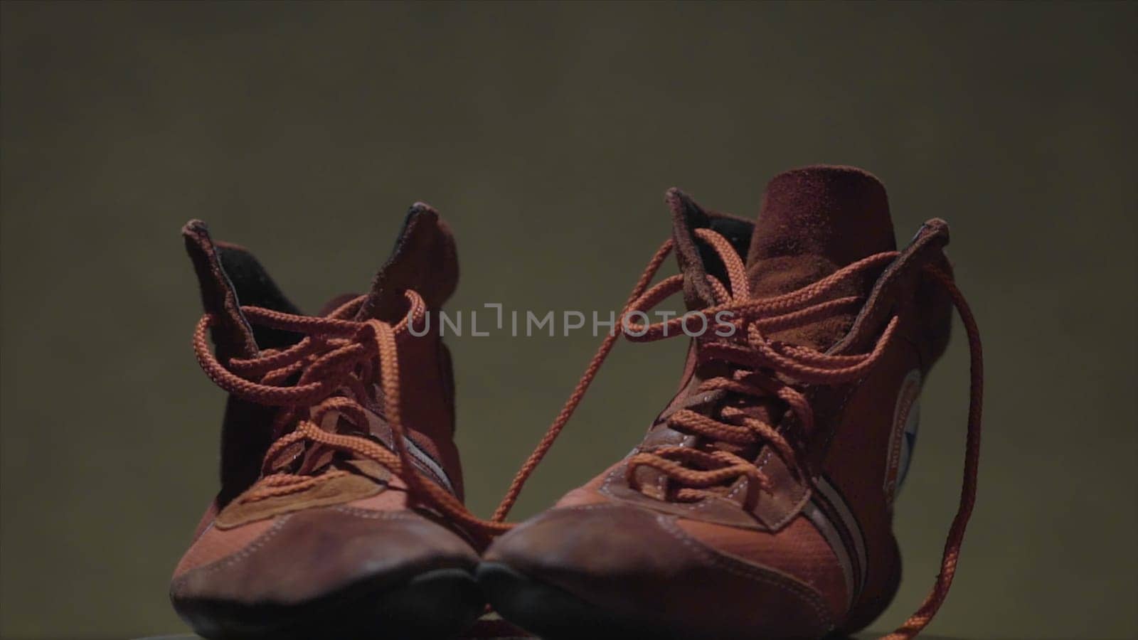 Red leather shoes for sports on a dark background. two shoes to fight standing on a grey background.