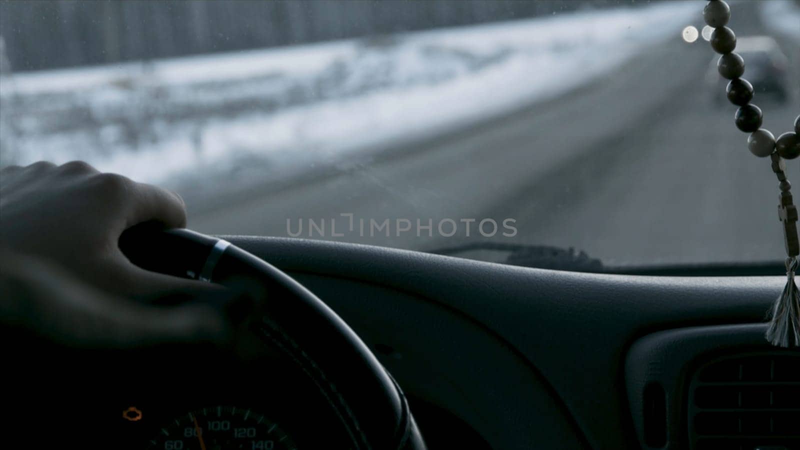 Car interior and winter road. Footage. Driver and passenger view from the cockpit of a car on the snowy road, back view p