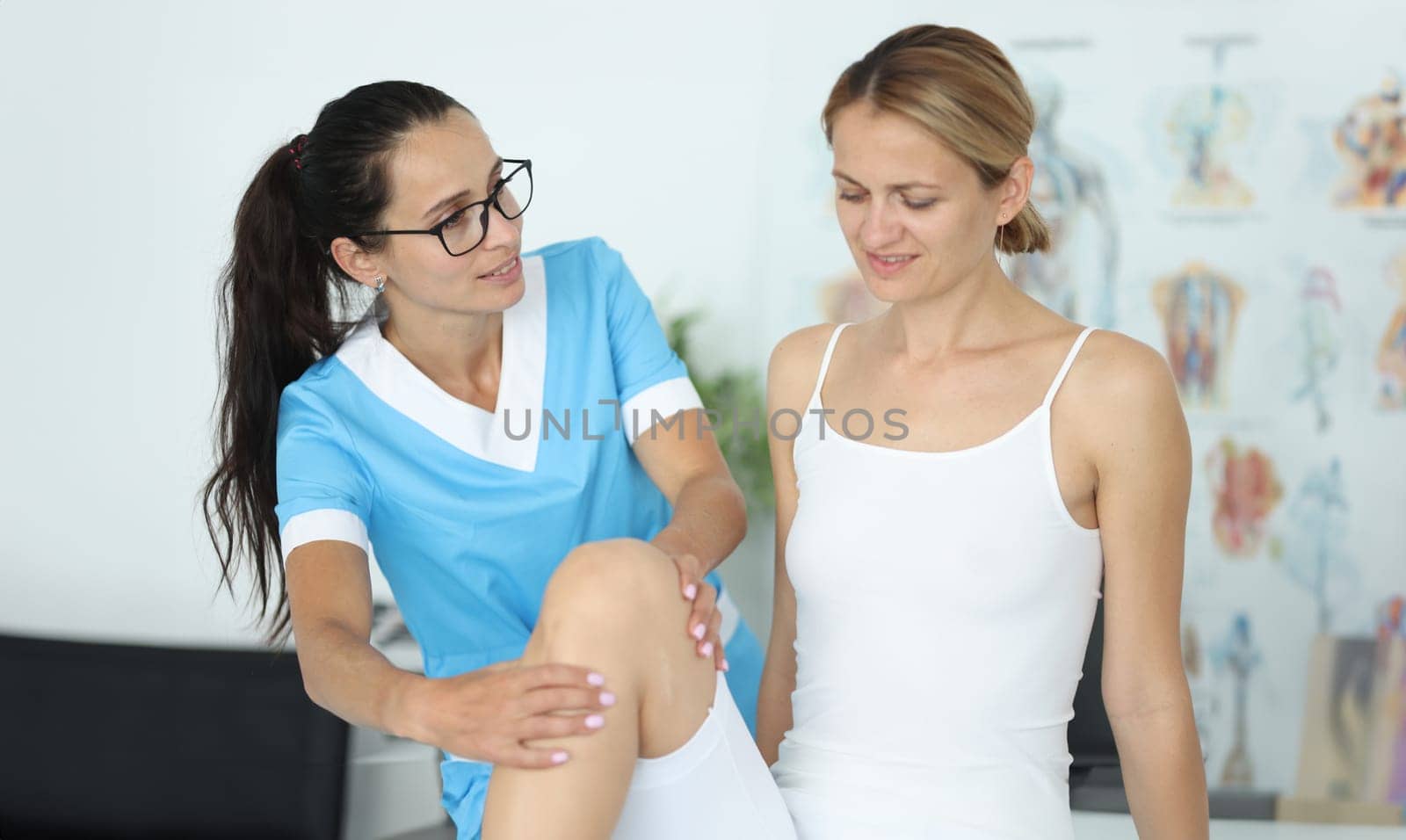 Female patient receiving medical care in rehabilitation center after leg injury by kuprevich
