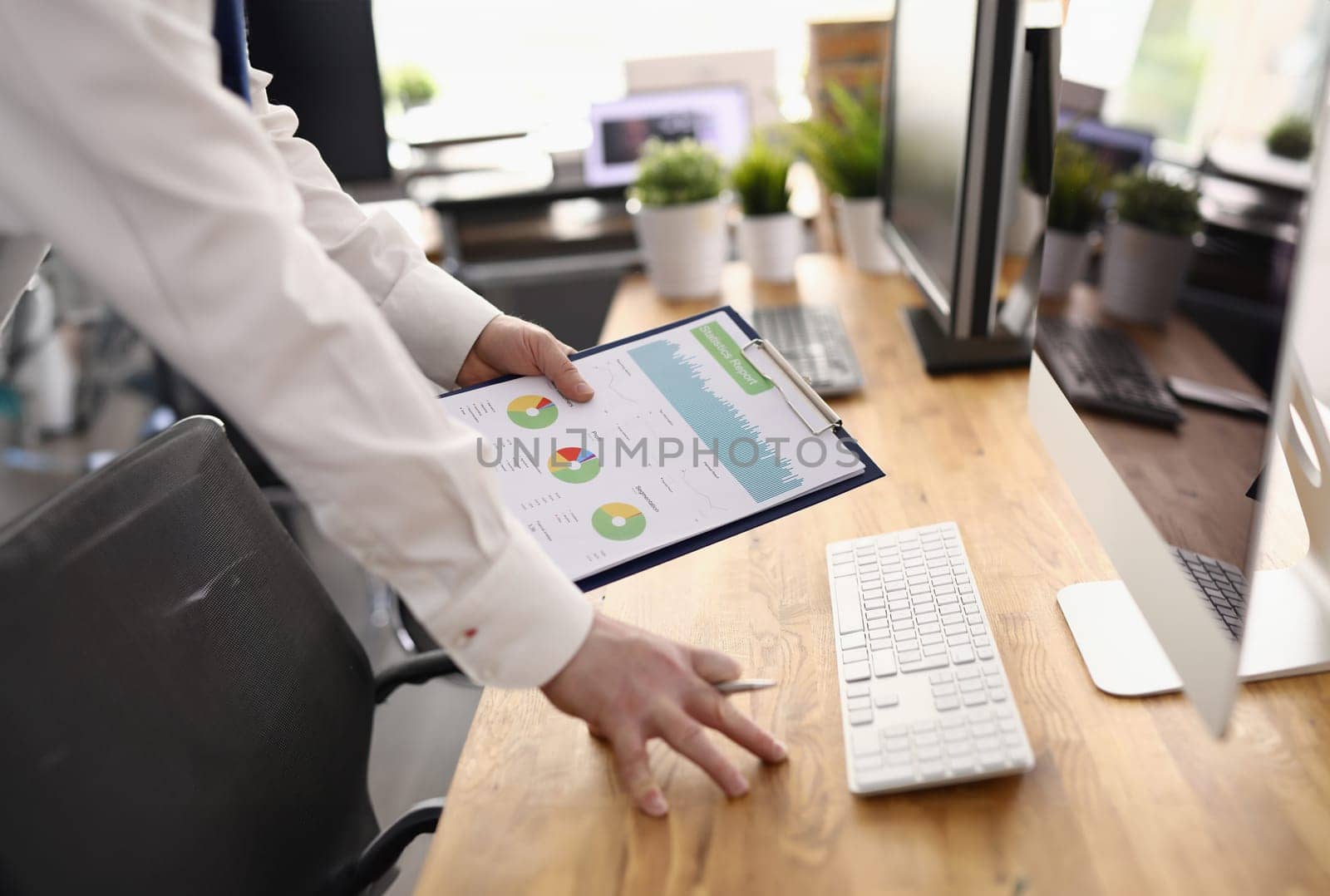 Analyst employee holds clipboard with graphs at workplace. Preparing statistics business indicators concept