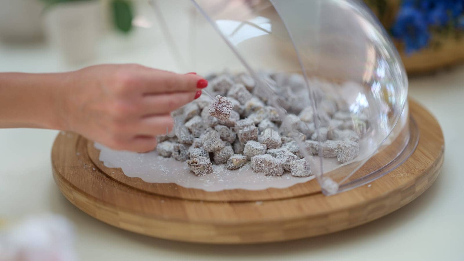 Woman hand taking piece of Turkish delight with coconut closeup. Turkish sweets concept