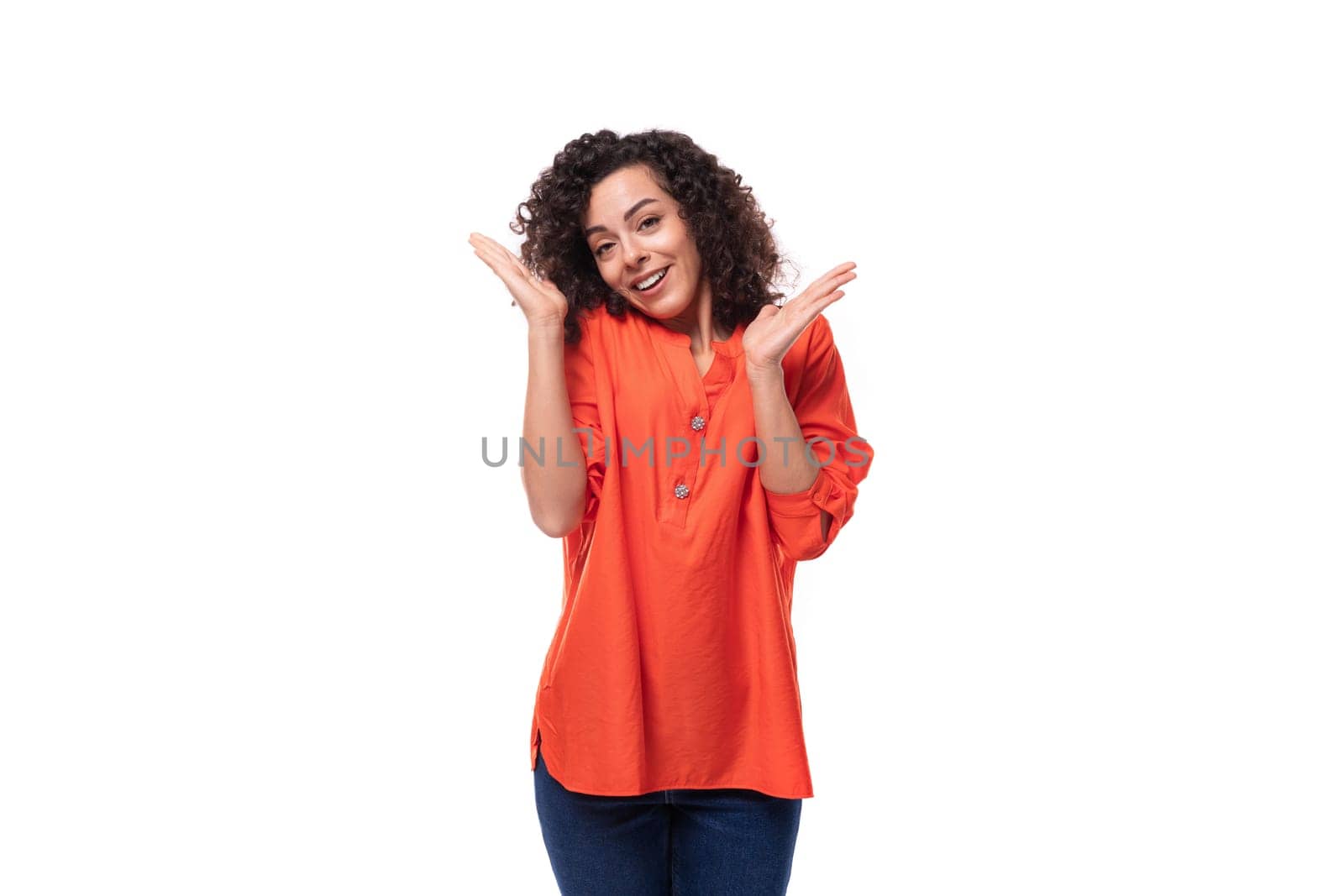 young dreamy caucasian business woman with wavy hair dressed in an orange blouse on a white background.