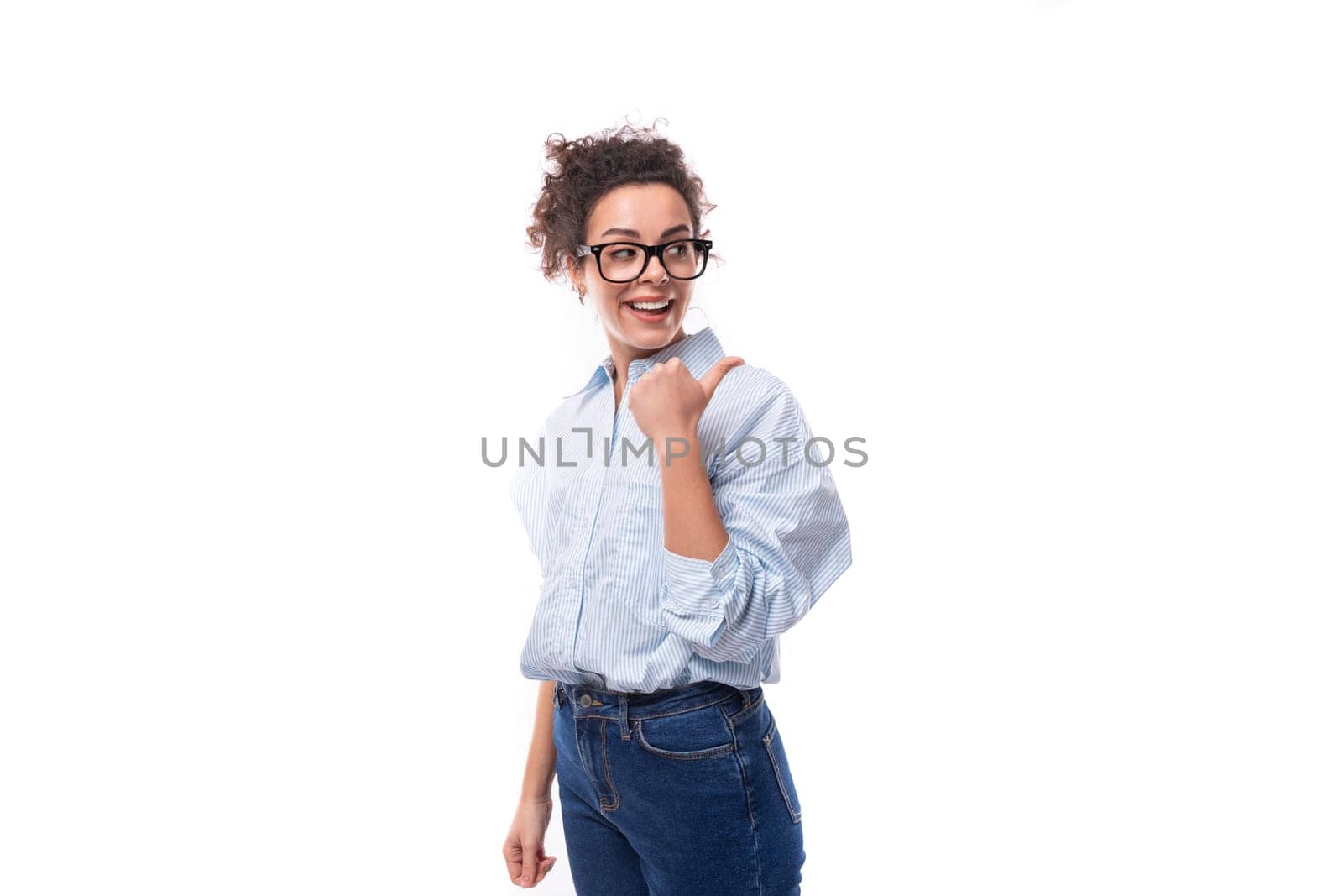 portrait of a young smiling fashionista caucasian woman working in the office who puts on glasses and a light blue shirt.