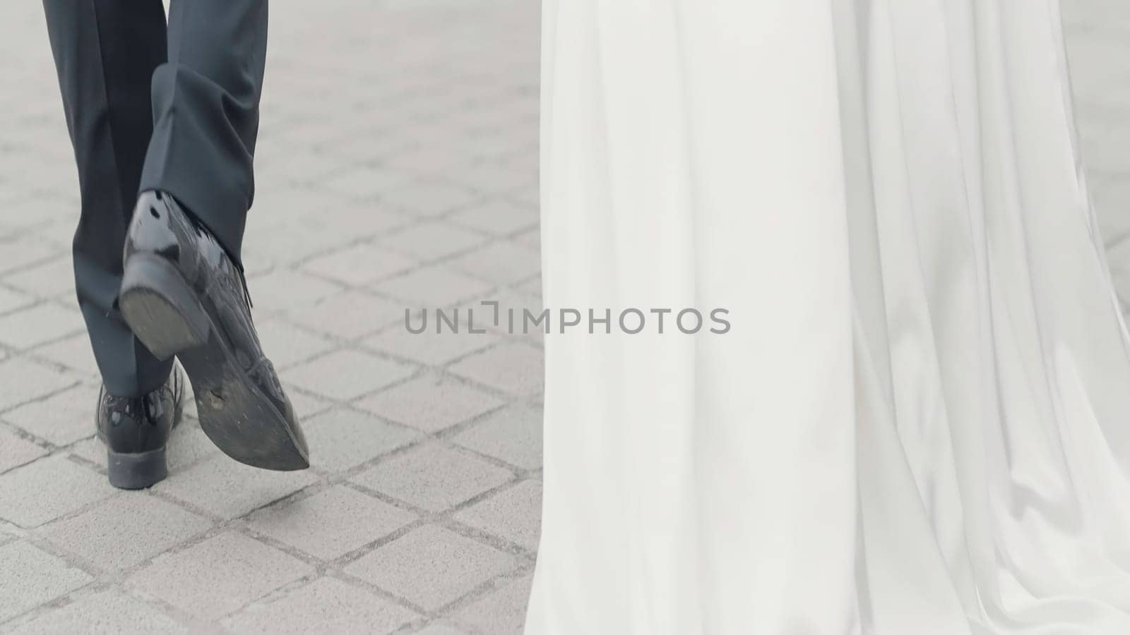 Detailed wedding photography. Action. The silhouette of the kissing newlyweds and their walk down the street in classic costumes. High quality 4k footage