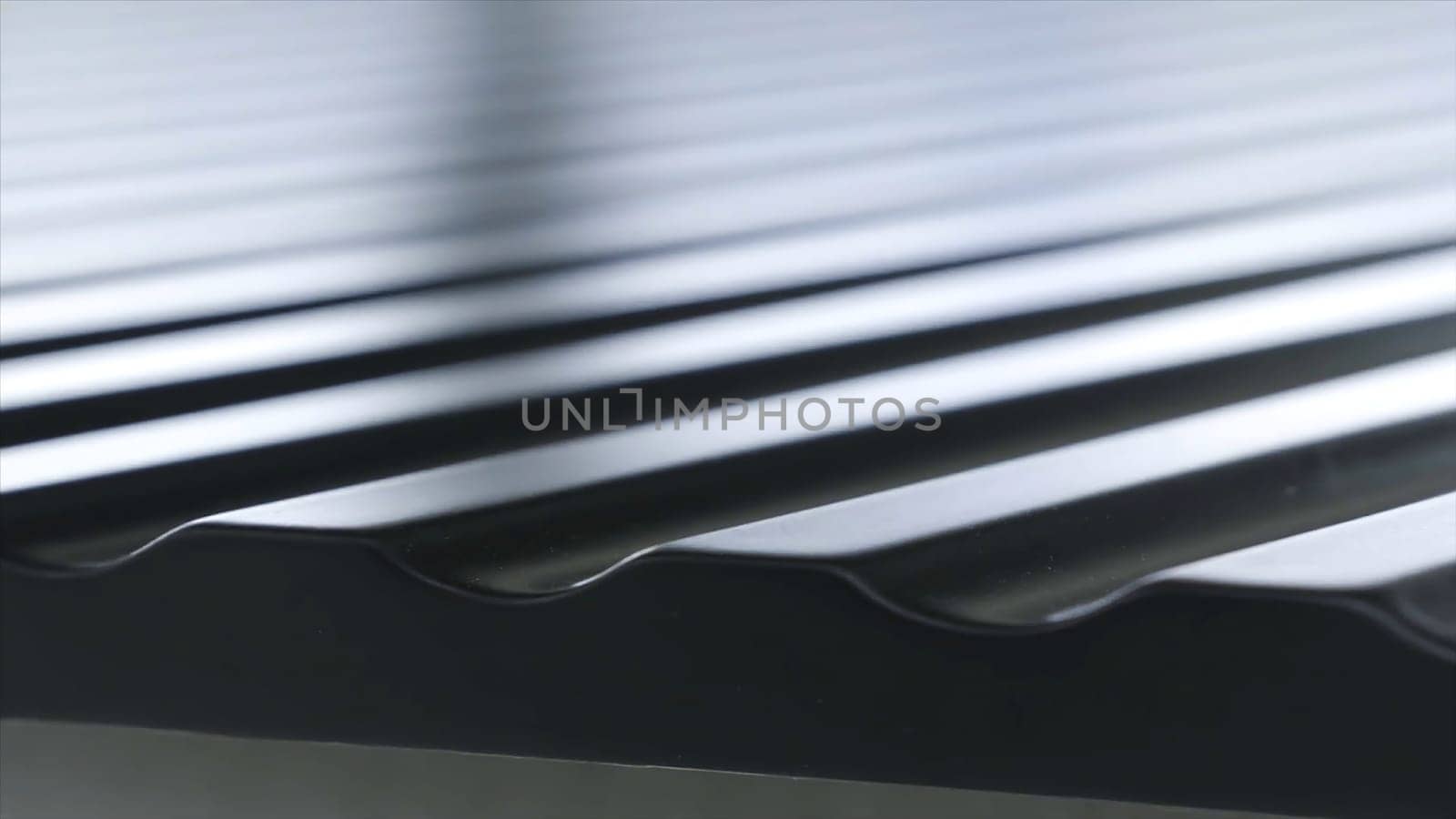 Close up view of black roofing waterproof material, construction and building concept. The edge of the roofing sheet, dark seam shingles.