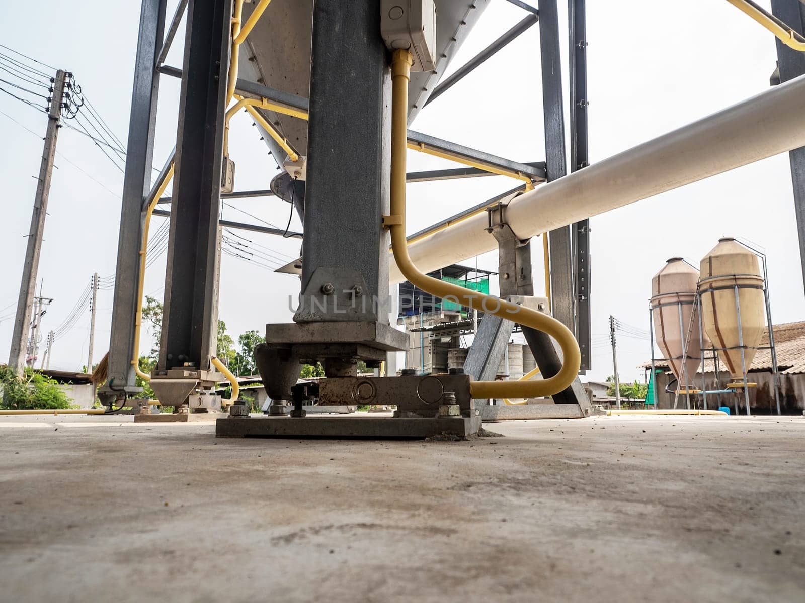 Weight-measuring equipment is supported under the legs of the large silo