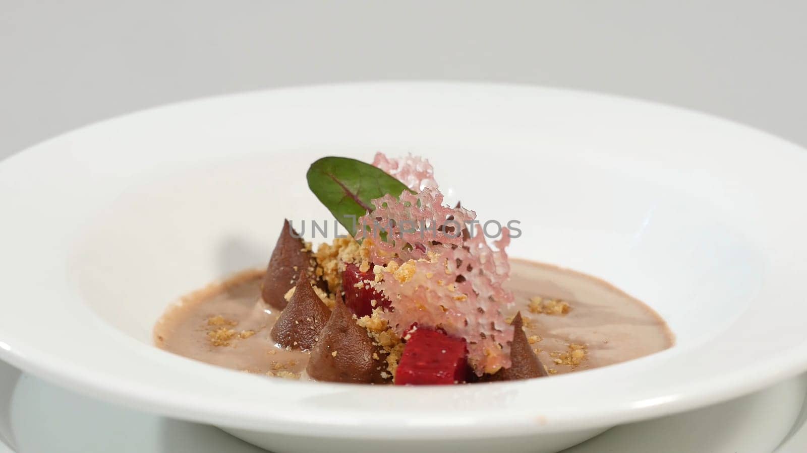 Beetroot salad. Salad with roasted beetroot, spinach, soft goat cheese and seeds in light plate over grey concrete textured background, oil in saucer. Close up