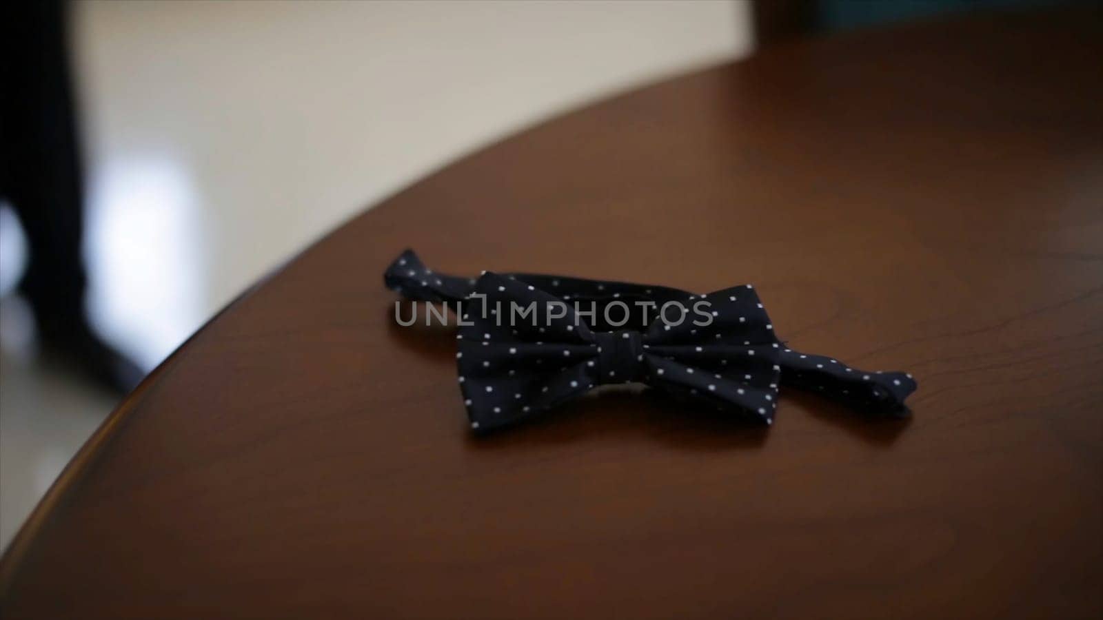 Wedding accessories. Bow tie in the hands of the groom. Man takes the bow-tie from the table HD