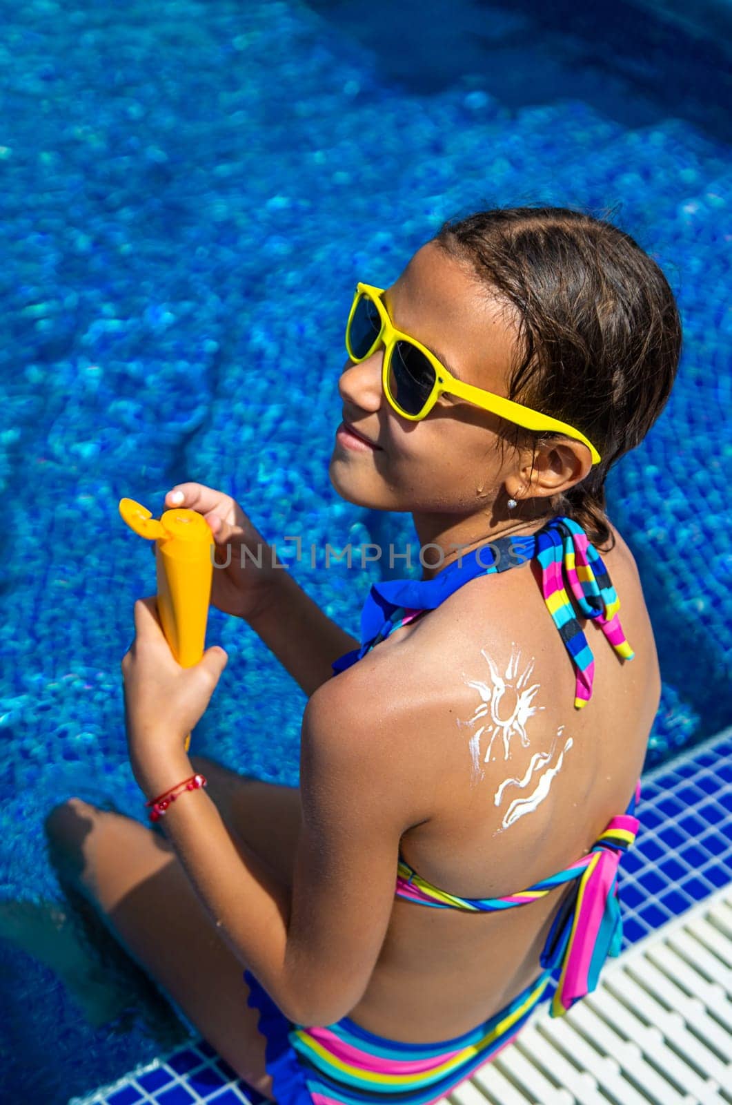 The child applies sunscreen. Selective focus. by yanadjana