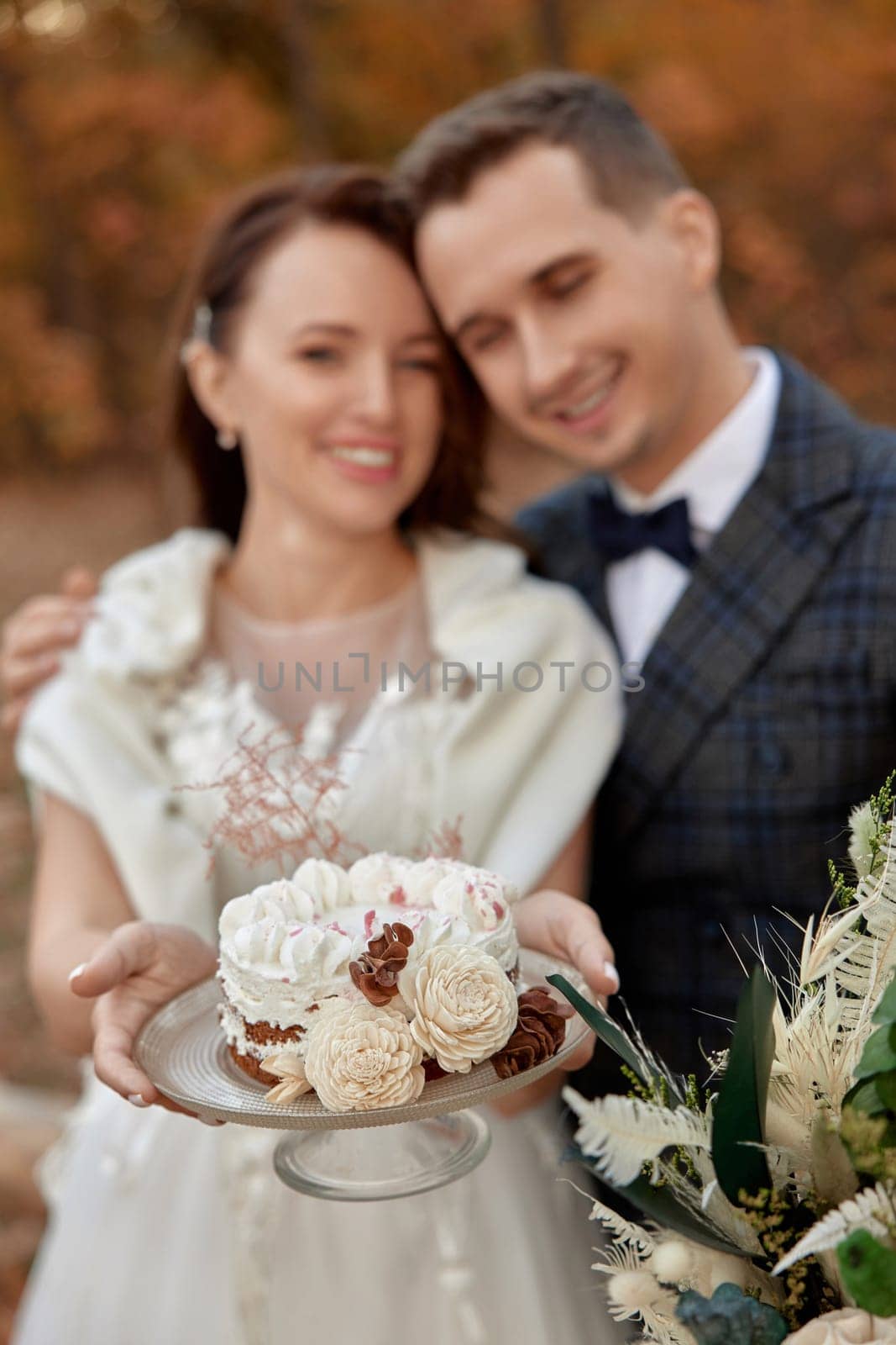 bride and groom on the nature in autumn . wedding couple with cake outdoor