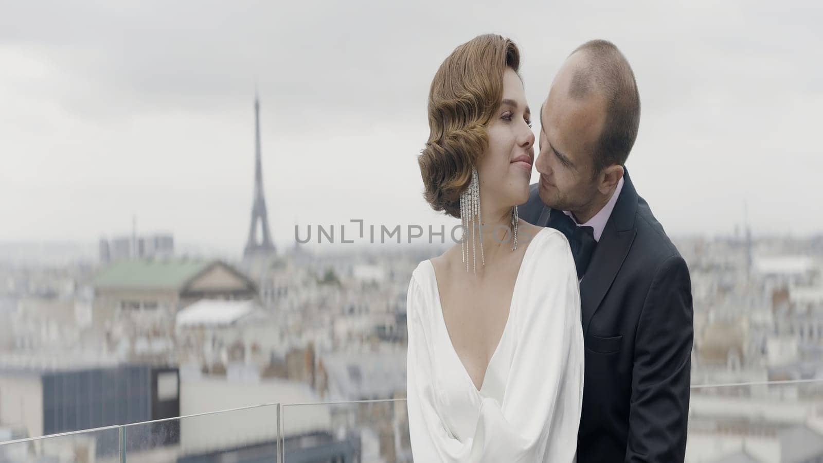 A beautiful couple against the background of nature and wind. Action. A beautiful brunette woman with curled hair and her love in a suit tenderly look at each other. High quality 4k footage