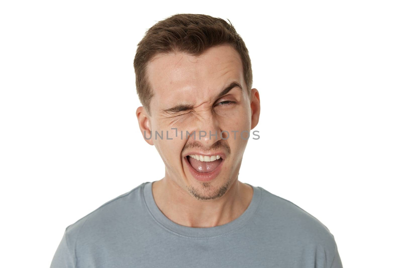 portrait of young happy man winking looking at the camera on white background
