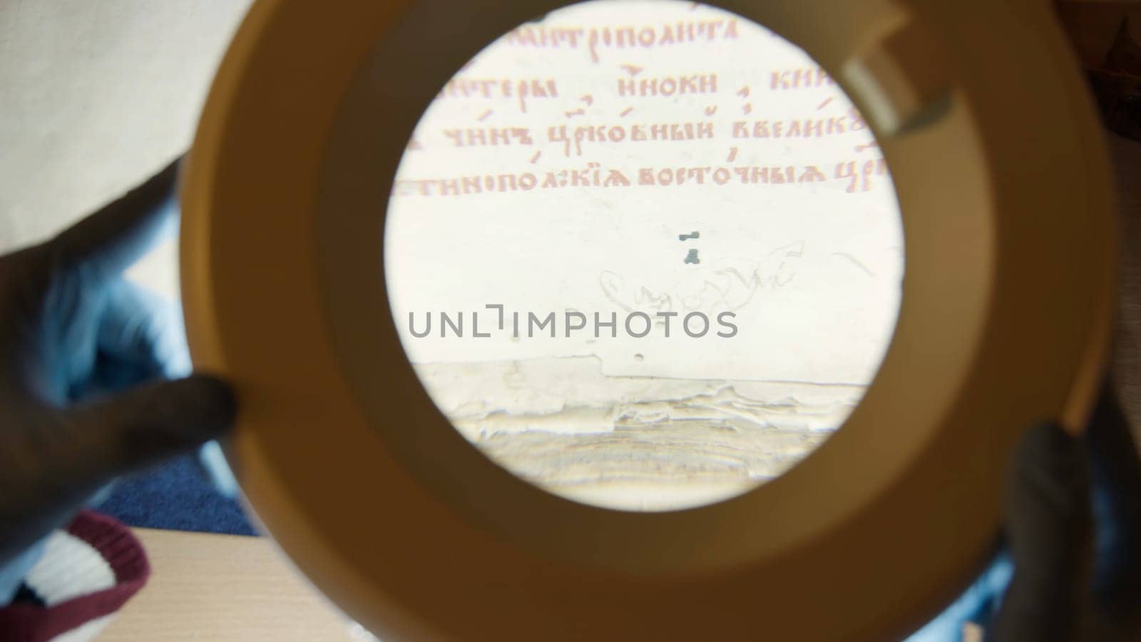 A large magnifying glass lamp that shines on an old letter. Stock footage.An old paper covered with Old Russian letters in the archive, which is examined by experts. High quality 4k footage