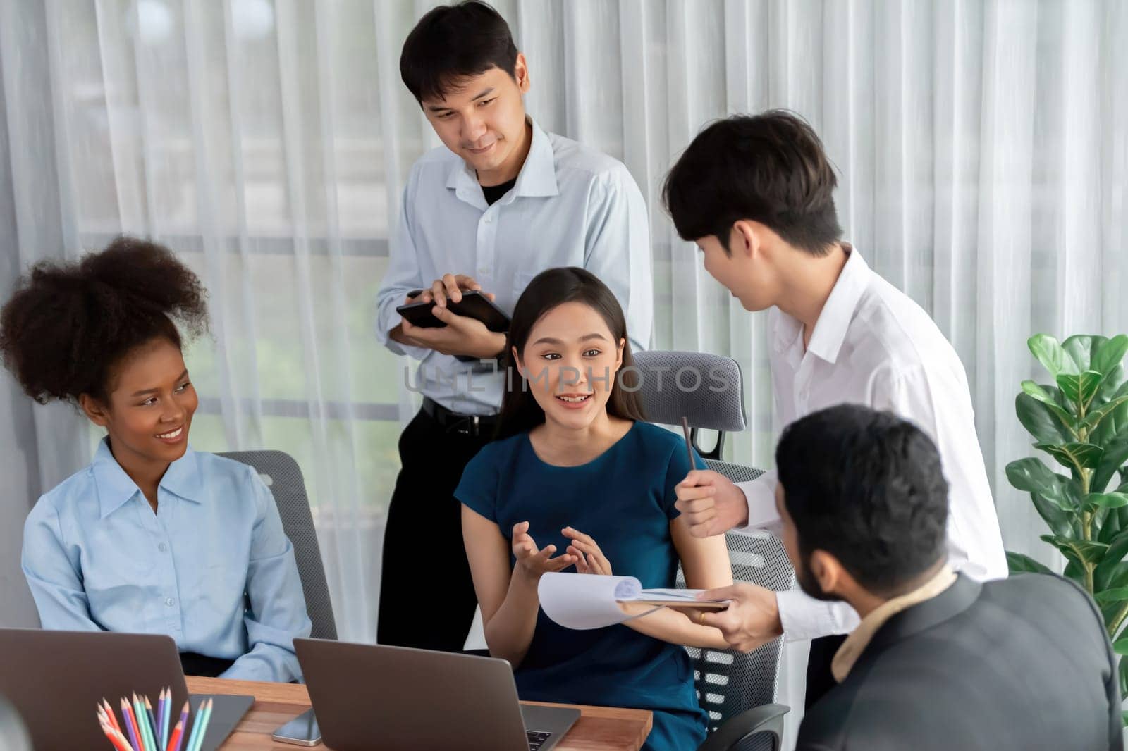 Happy diverse business people work together, discussing in corporate office. Professional and diversity teamwork discuss business plan on desk with laptop. Modern multicultural office worker. Concord