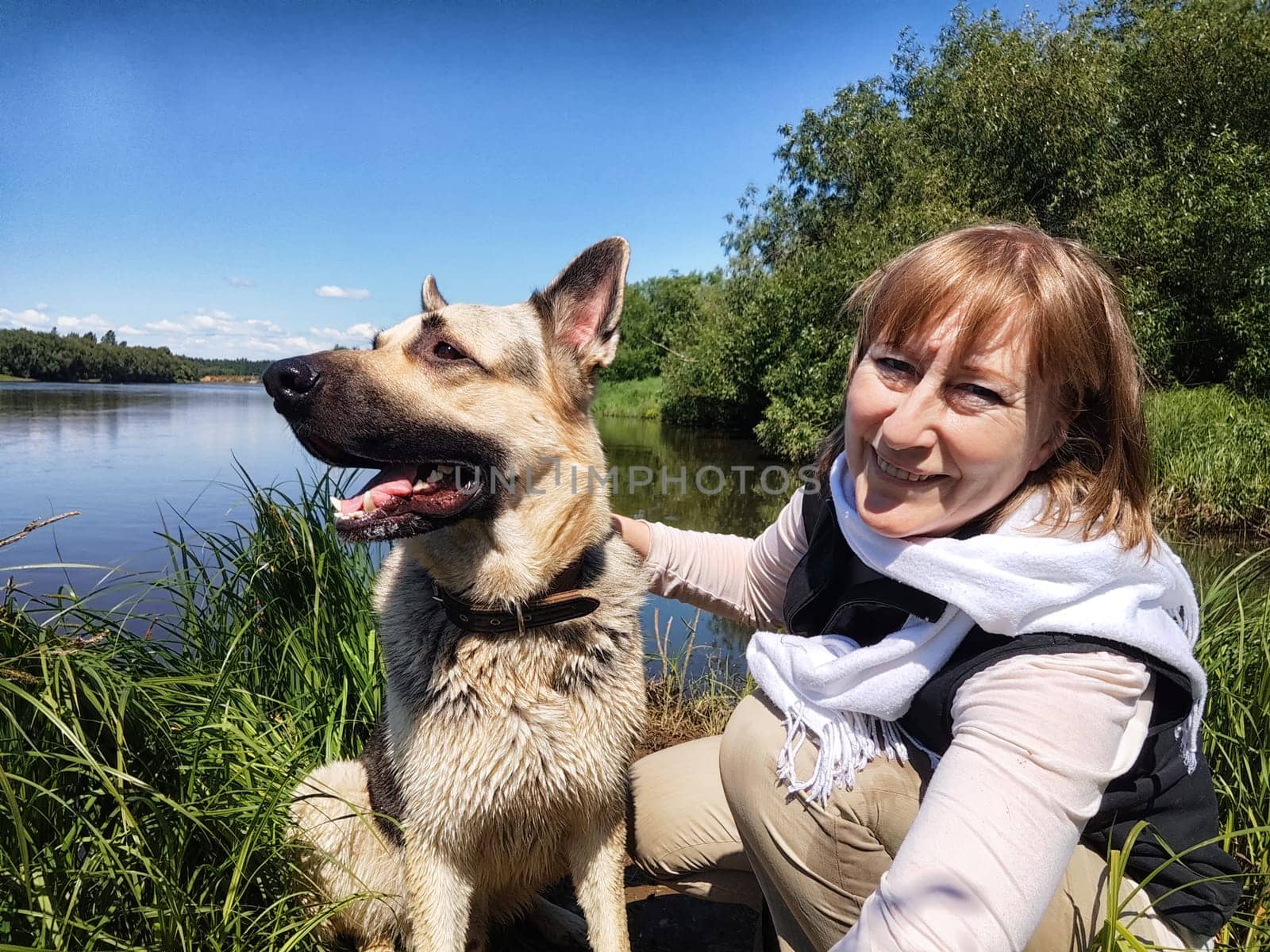 Dog German Shepherd and woman or girl in nature in summer, spring, summer day. Russian eastern European dog and the mistress, trainer veo outside and outdoors