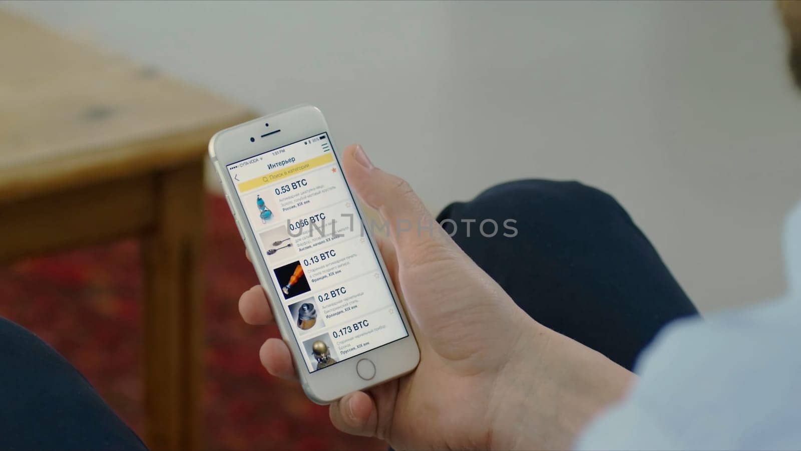 Russia, Moscow - May 2018: Purchase bitcoins with a smartphone. Stock. Close-up of a hand with a smartphone on a background of crypto currency.