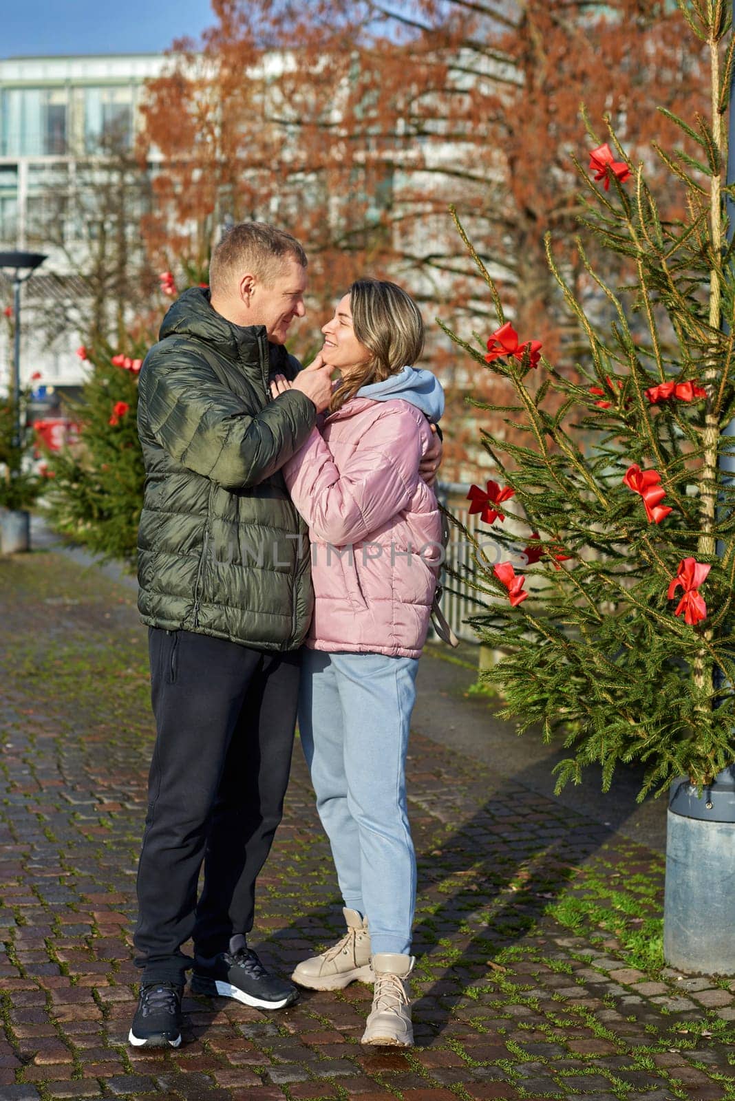 Portrait of young attractive people, lovely couple enjoying cozy atmosphere on fair in Christmas Eve. Spending time together. Concept of national traditions, winter holidays, fashion, festivities