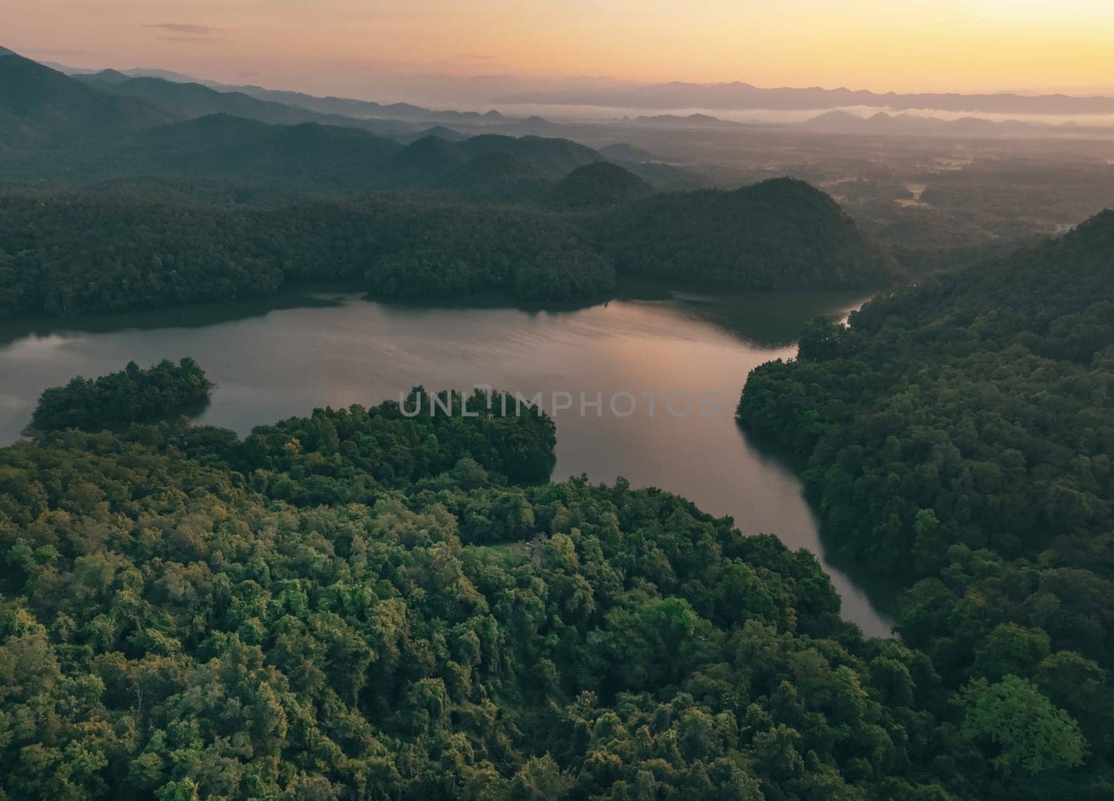 Beautiful landscape of green mountains and lake in the morning with sunrise sky. Nature landscape. Watershed forest. Water and forest sustainability concept. Aerial view of mountain with green trees. by Fahroni