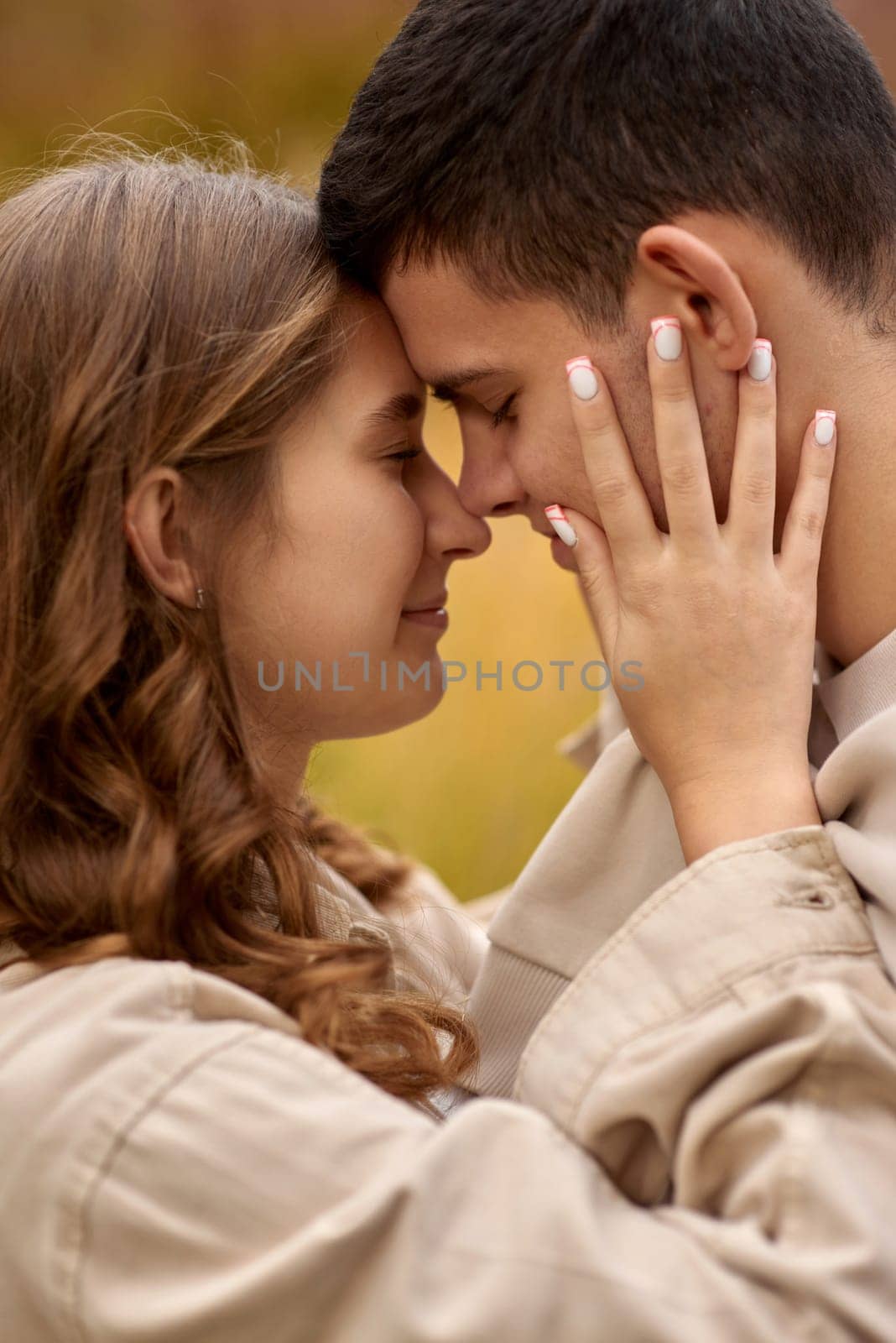 Young Cute Female Hugs Boyfriend. In Autumn Outdoor. Lovers Walking in Park. Attractive Funny Couple. Lovestory in Forest. Man and Woman. Cute Lovers in the Park. Family Concept. Happy Couple.